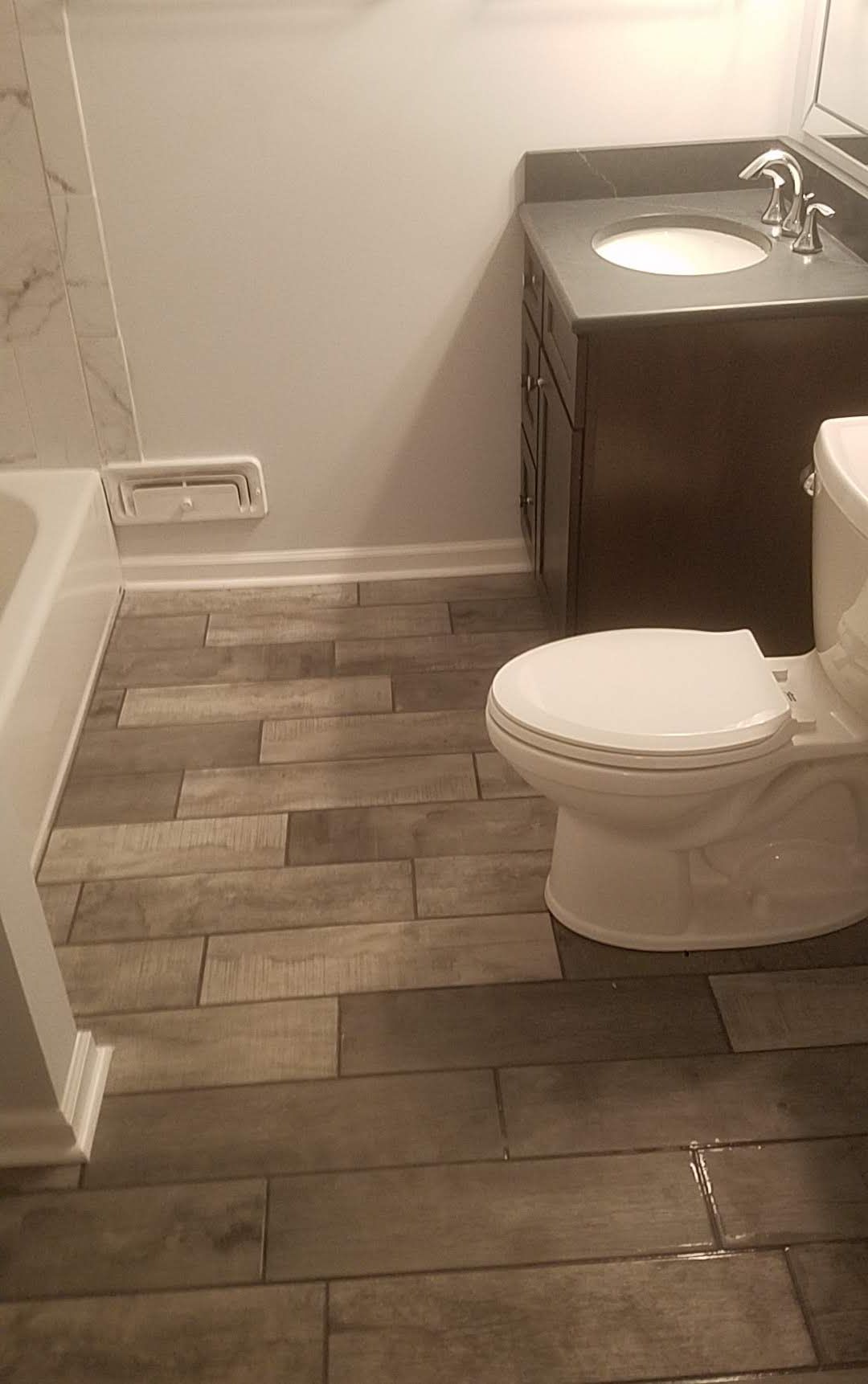 A bathroom with a toilet , sink , and bathtub.