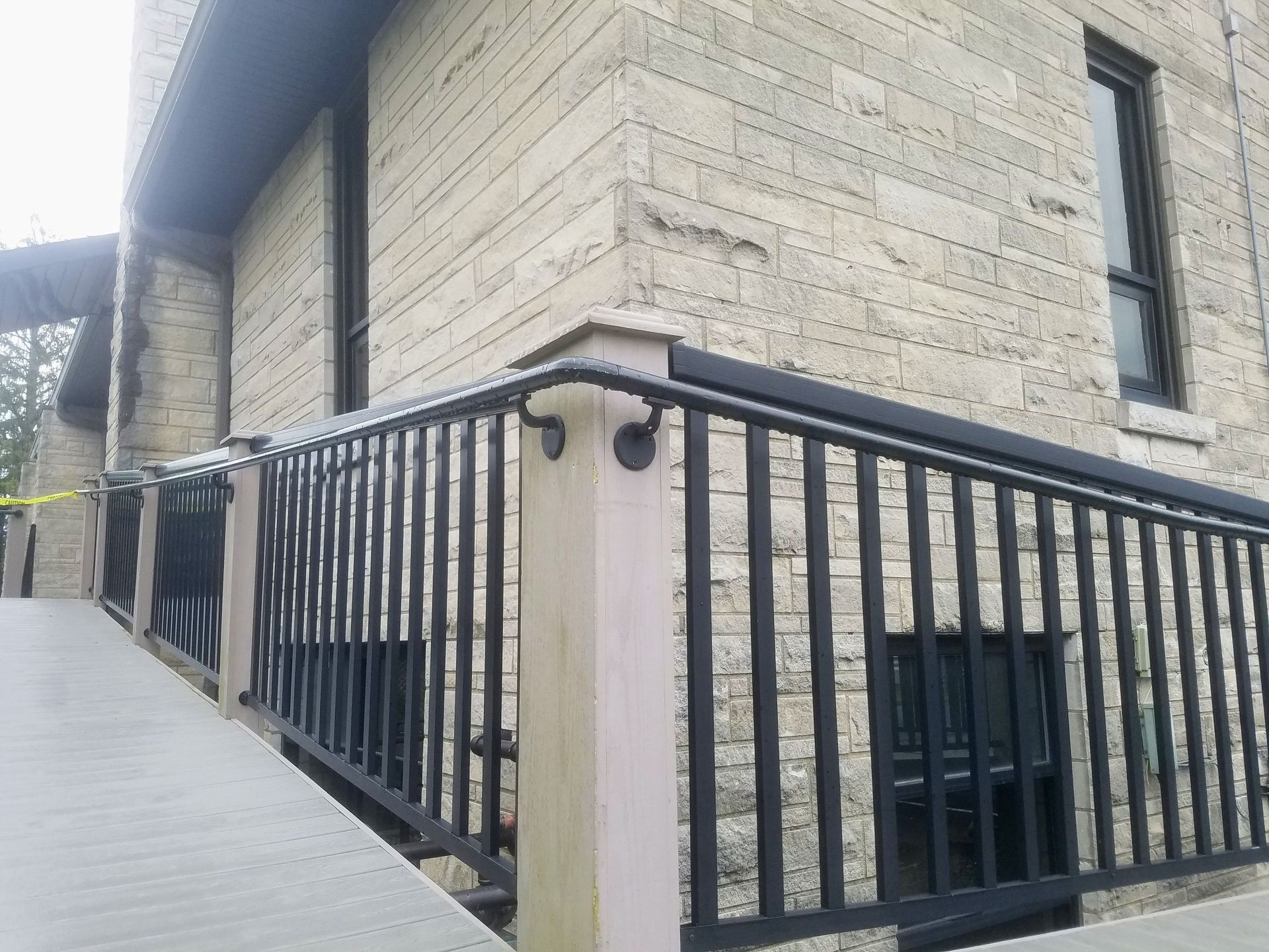 A brick building with a black railing on the side of it.