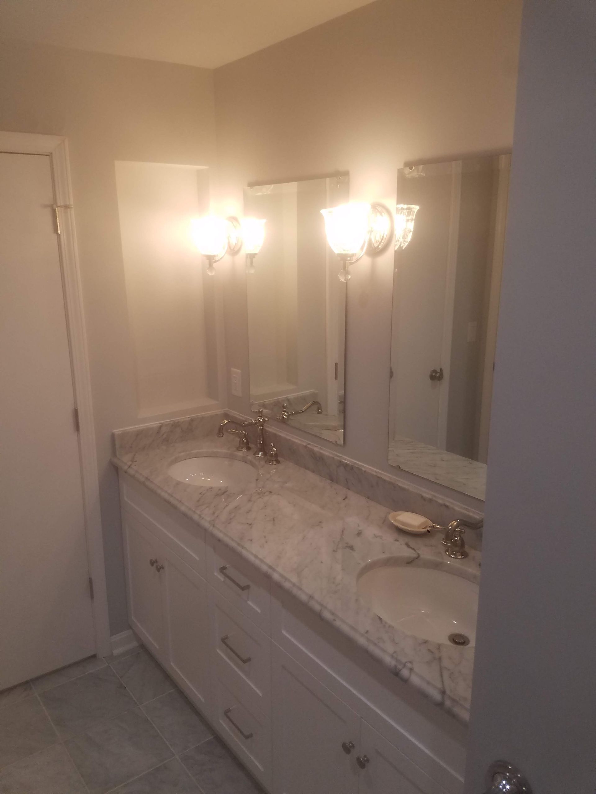 A bathroom with two sinks and a large mirror.
