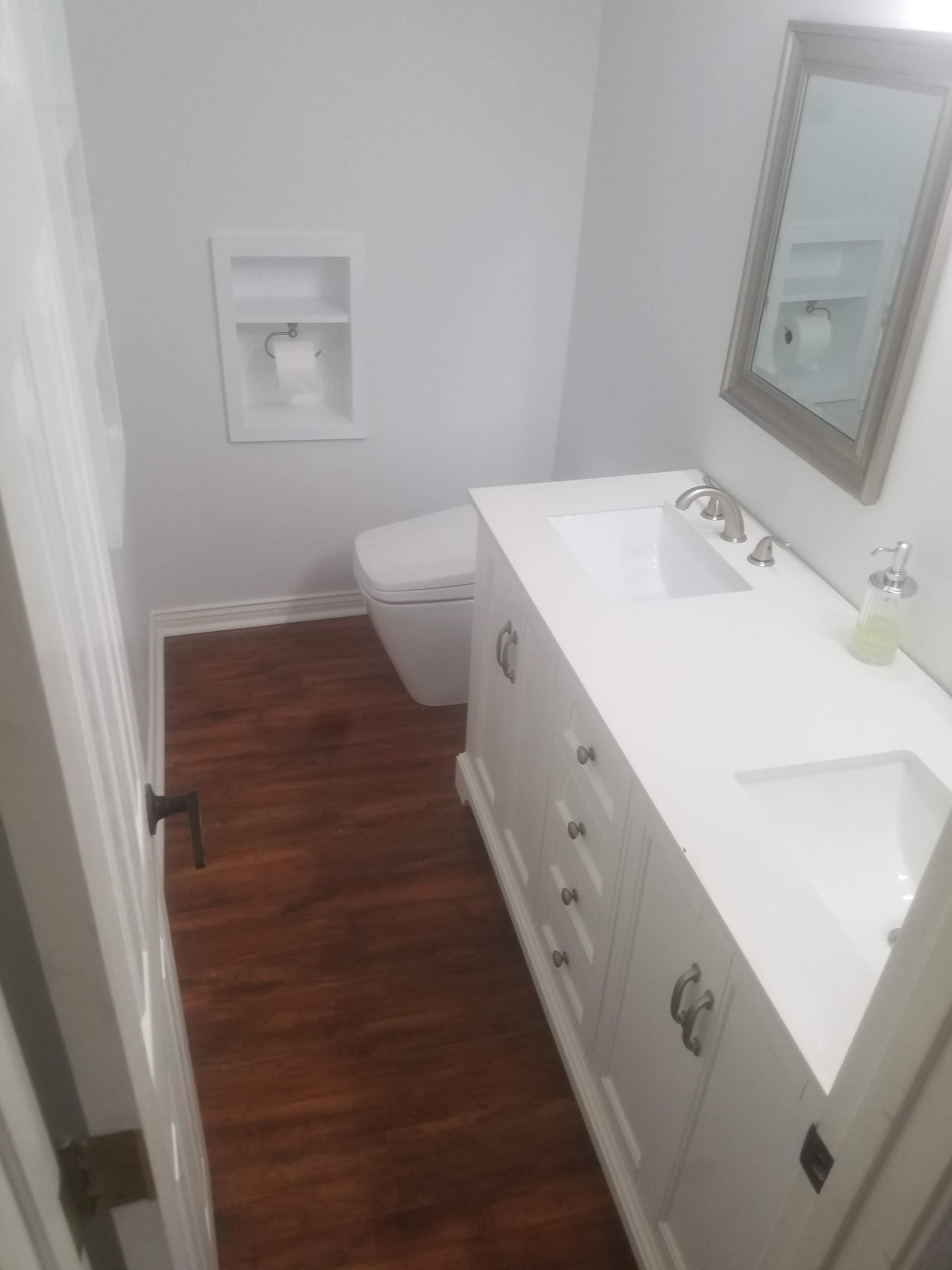 A bathroom with a sink , toilet and mirror.