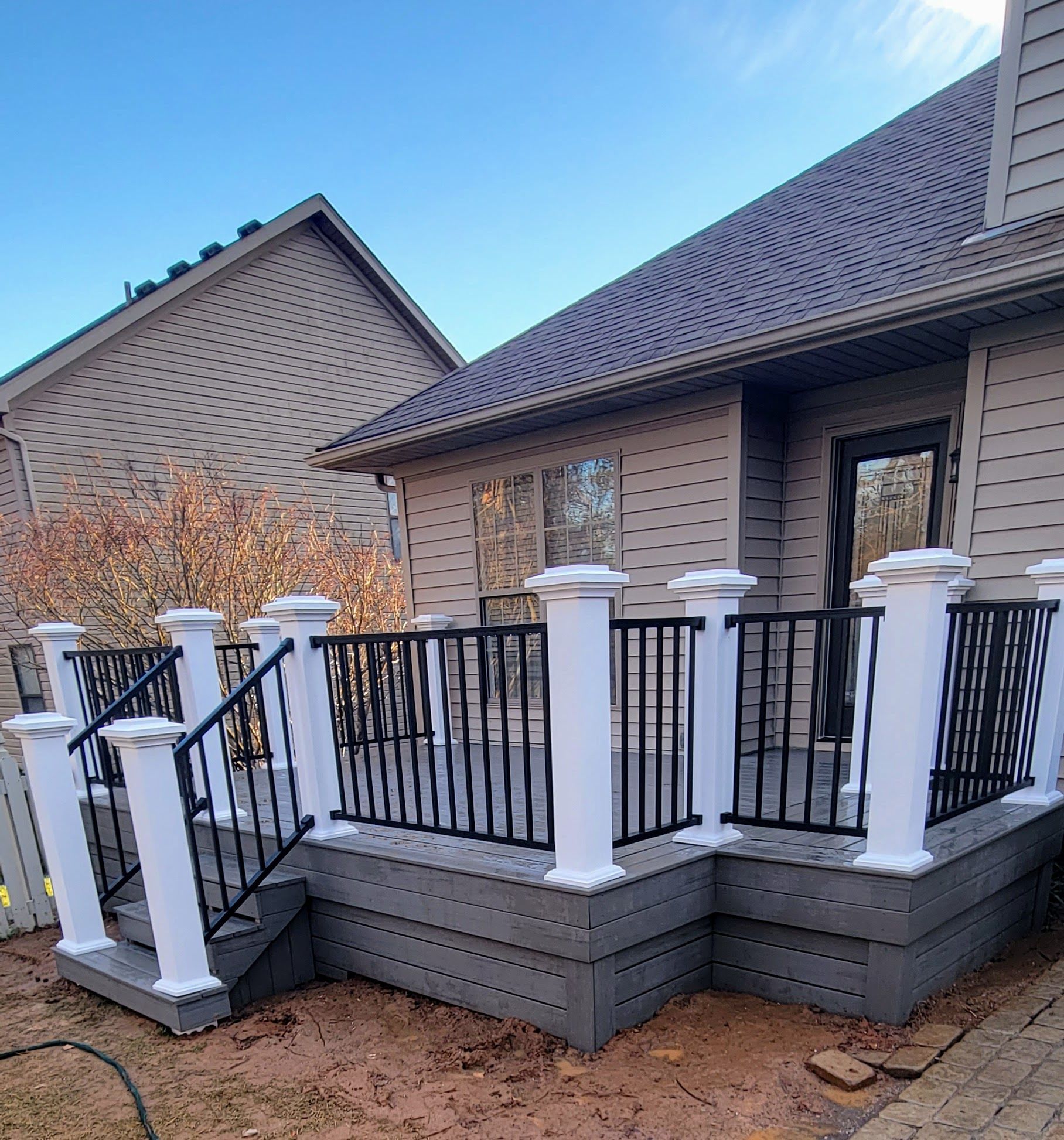 A house with a deck and stairs in front of it