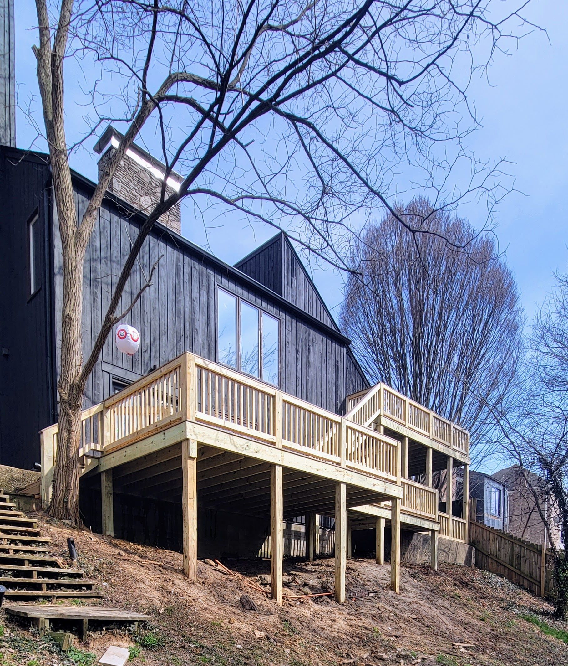 A house with a large wooden deck in front of it.