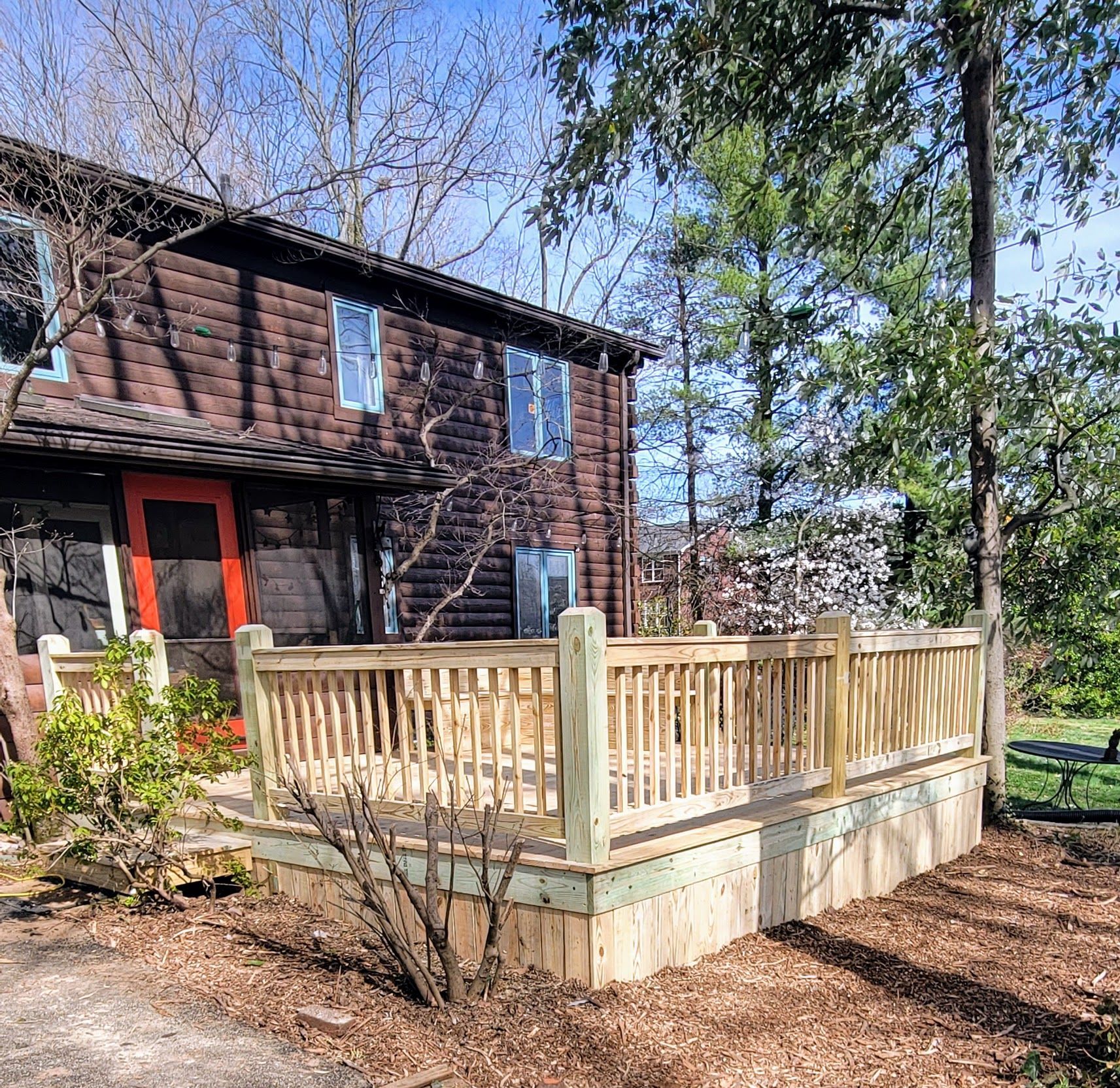 A log cabin with a wooden deck in front of it.