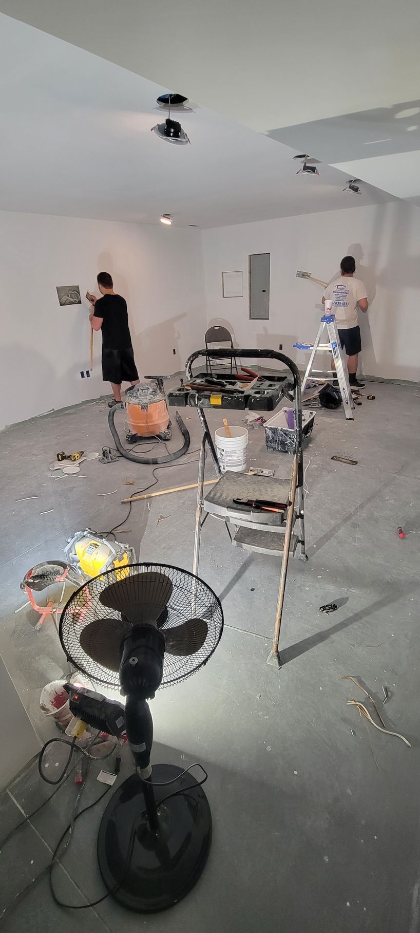 A group of people are painting walls in a room.