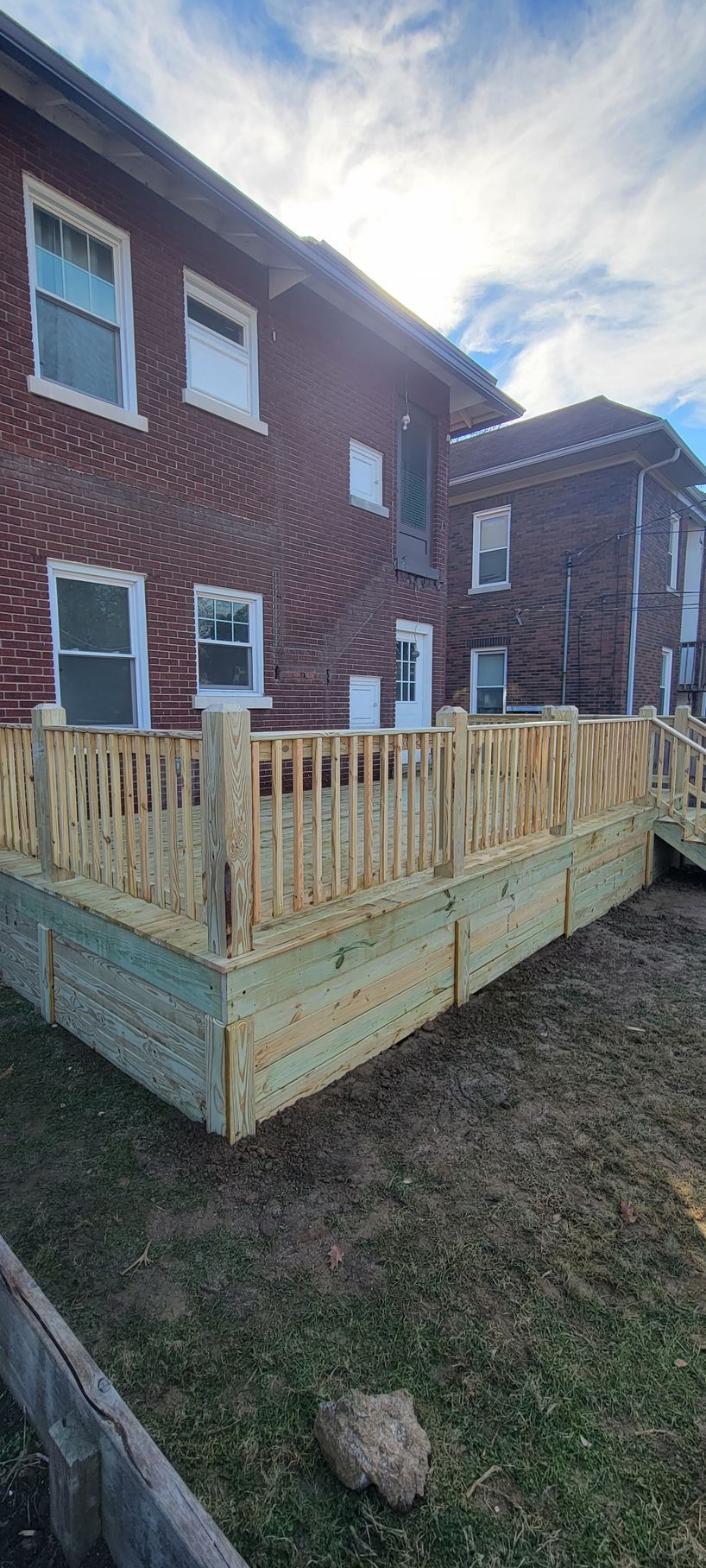 A wooden deck is being built in front of a brick building.