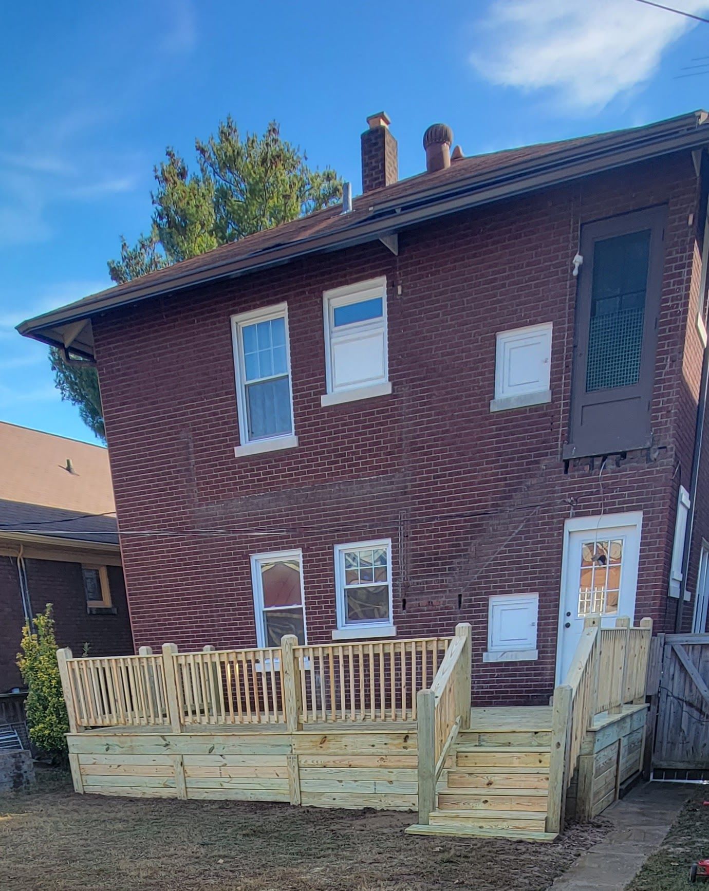 A brick house with a wooden deck in front of it