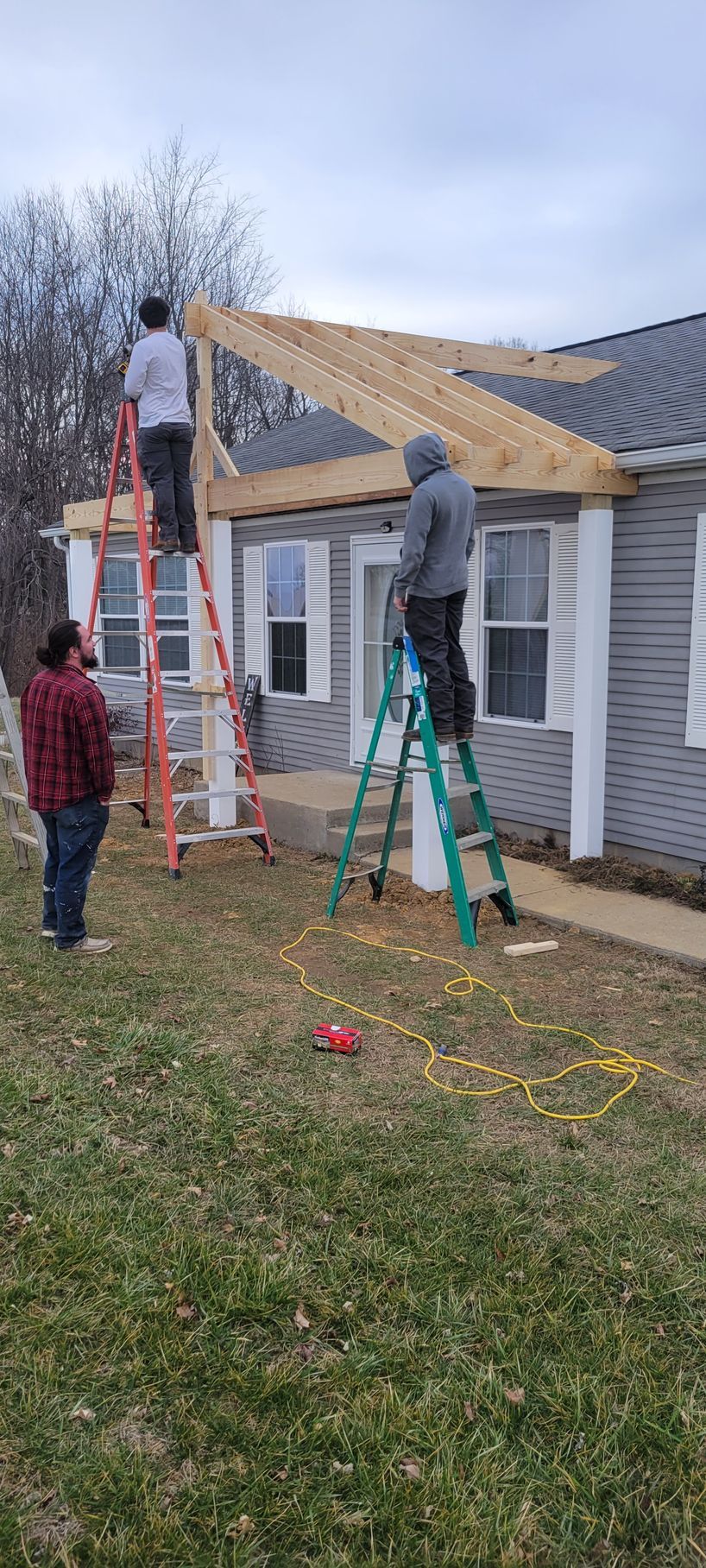 A group of people are working on the roof of a house.