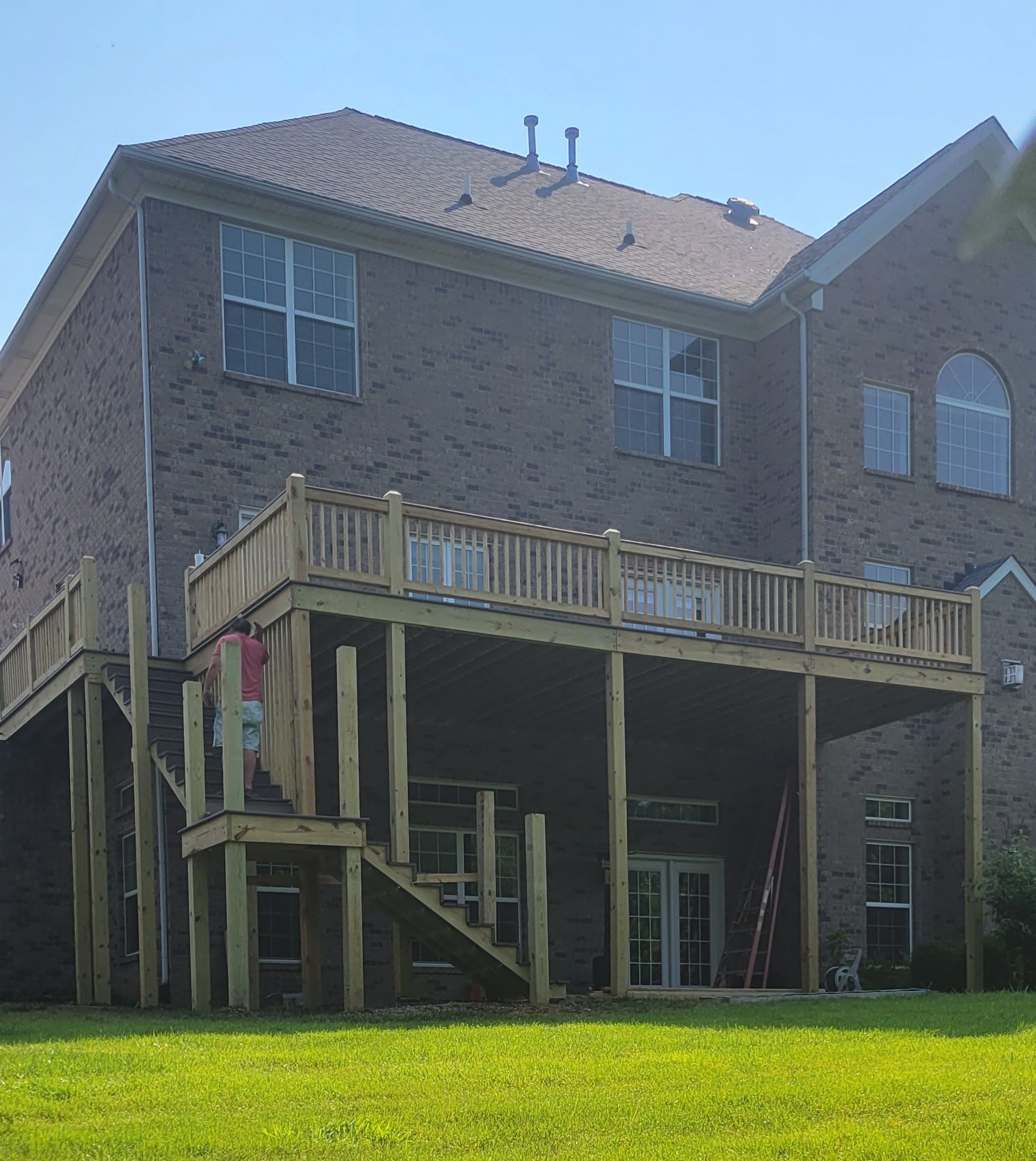 A large brick house with a large wooden deck