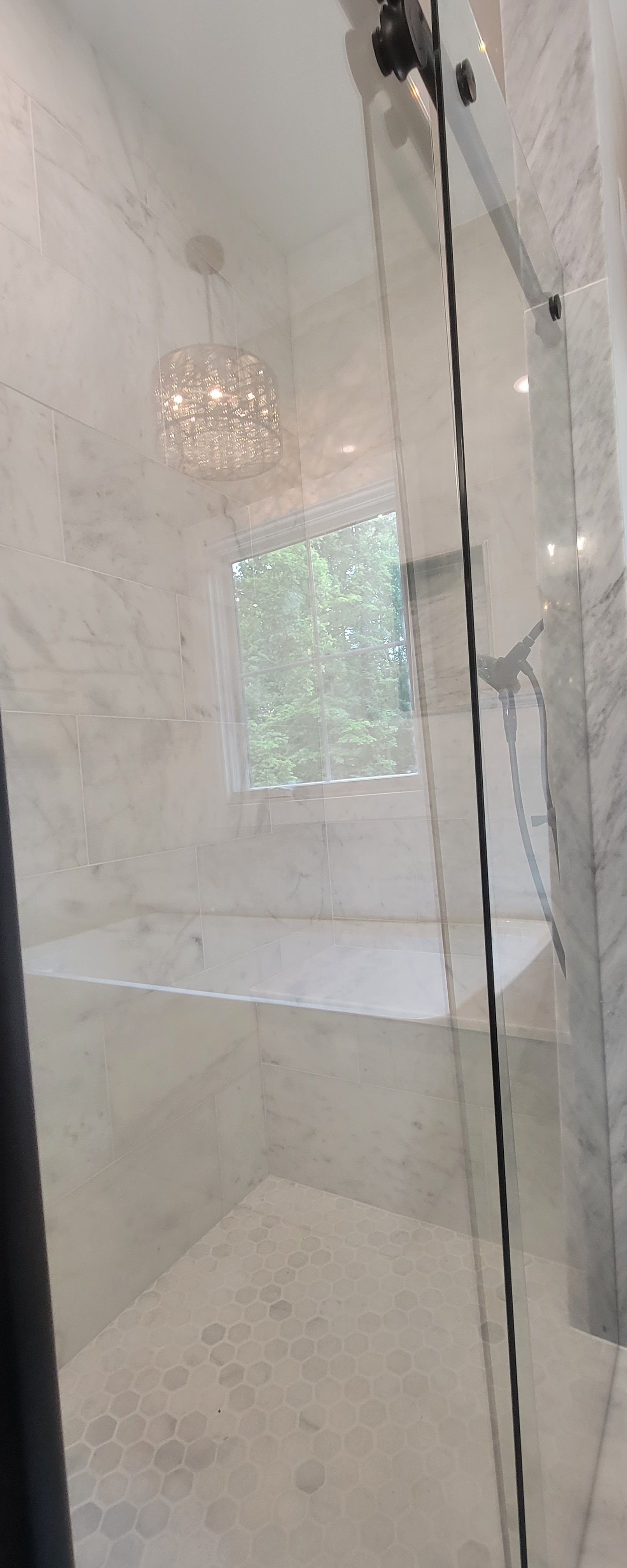 A bathroom with a sliding glass shower door and a bathtub.