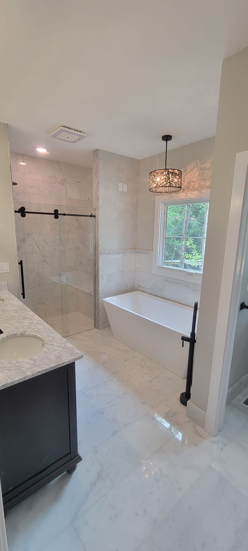 A bathroom with a tub , sink , and shower.