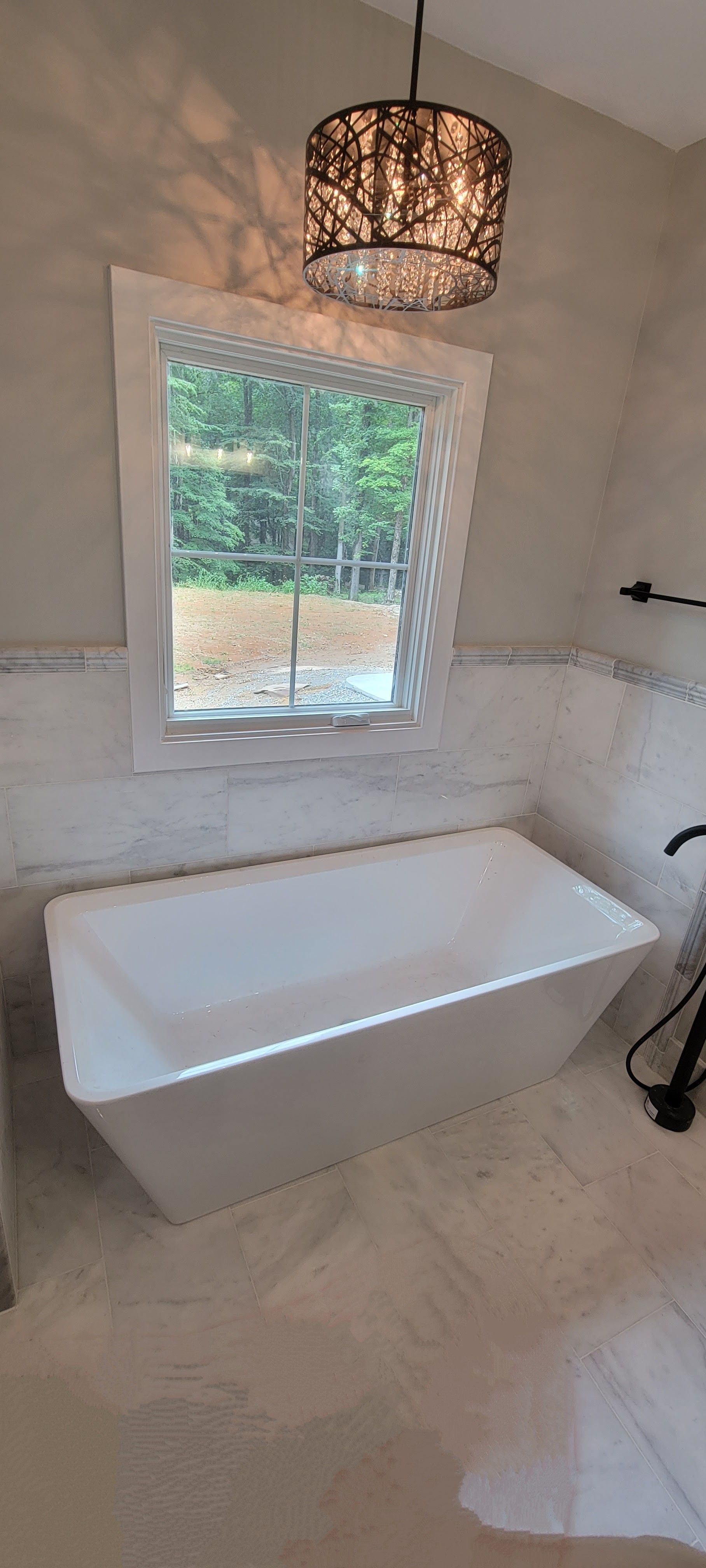 A bathroom with a bathtub and a window.