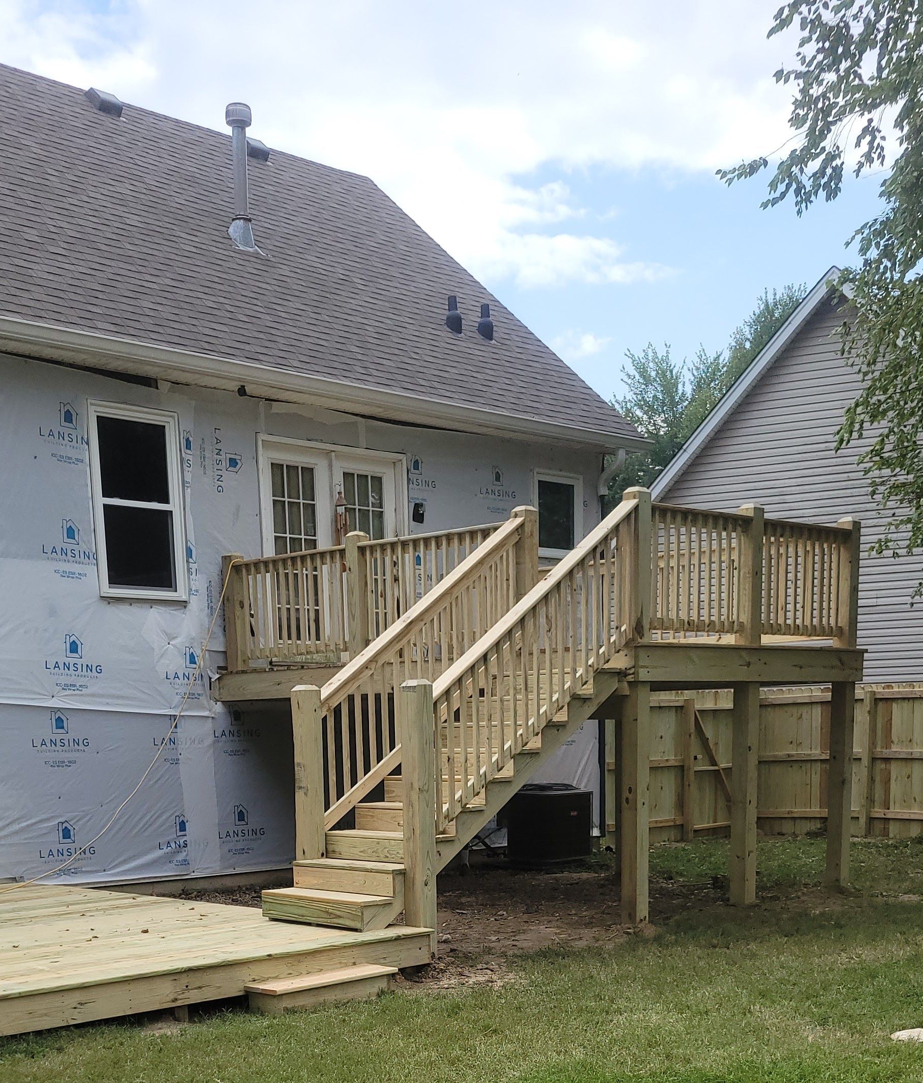 A house with a wooden deck and stairs in front of it
