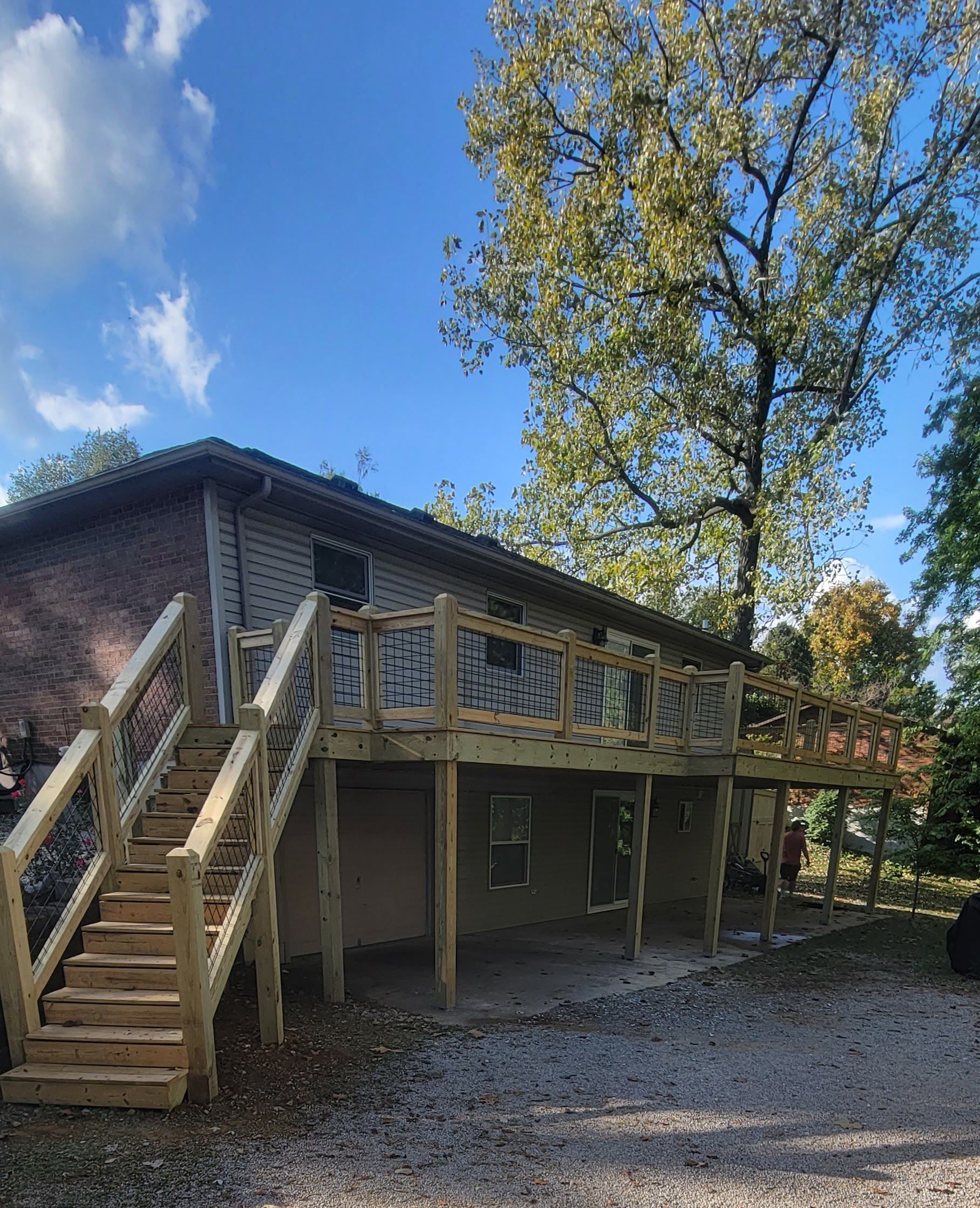 A house with a wooden deck and stairs in front of it.