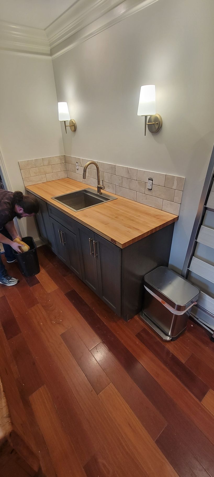 A kitchen with a sink and a wooden counter top.