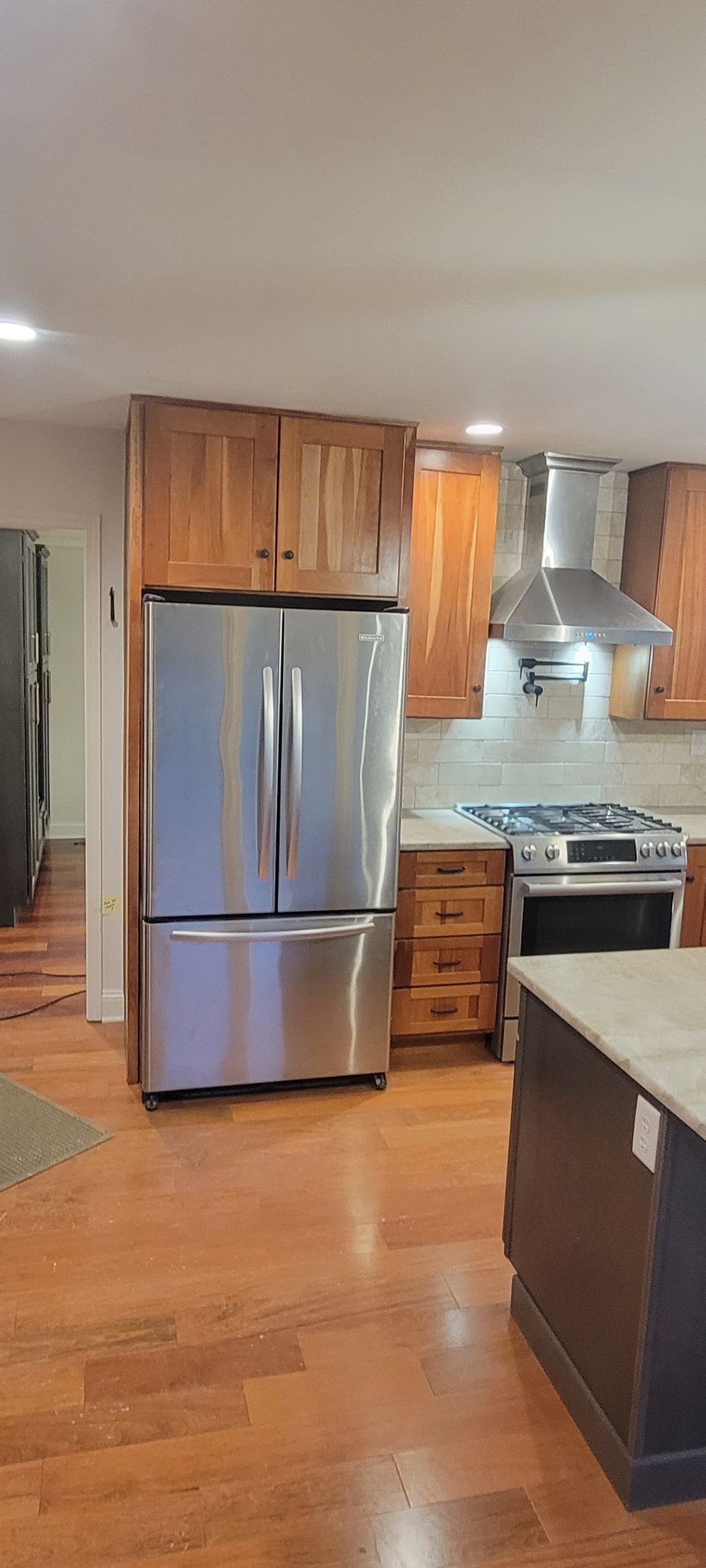 A kitchen with stainless steel appliances and wooden cabinets.