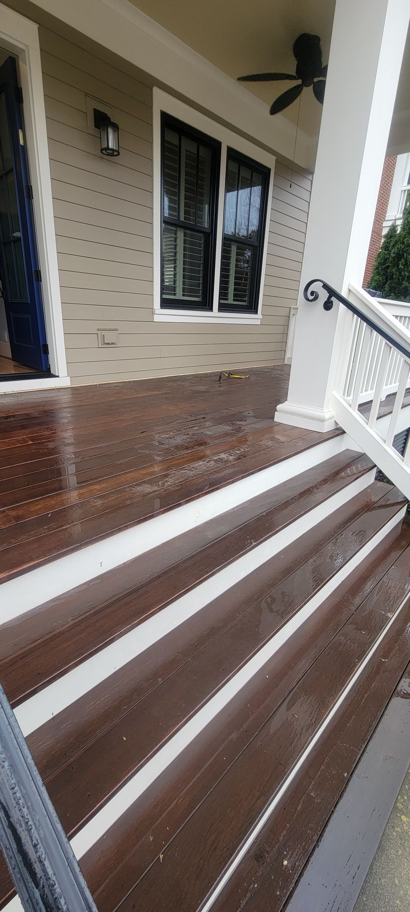 A porch with stairs leading up to it and a ceiling fan.