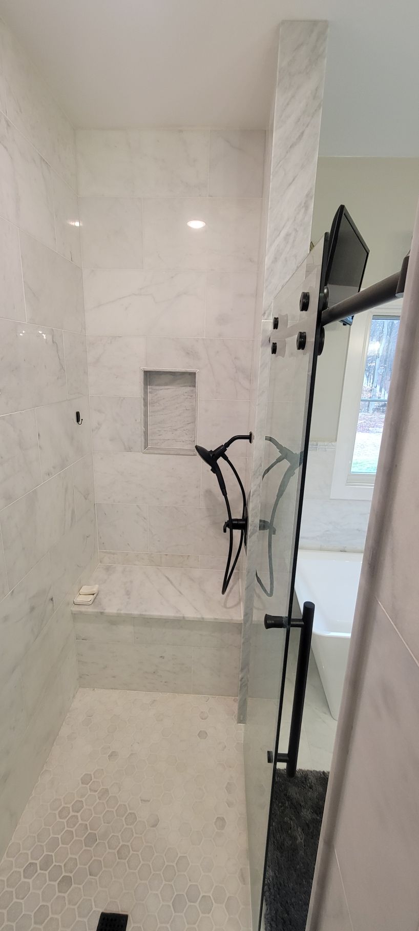 A bathroom with a walk in shower and a bathtub.