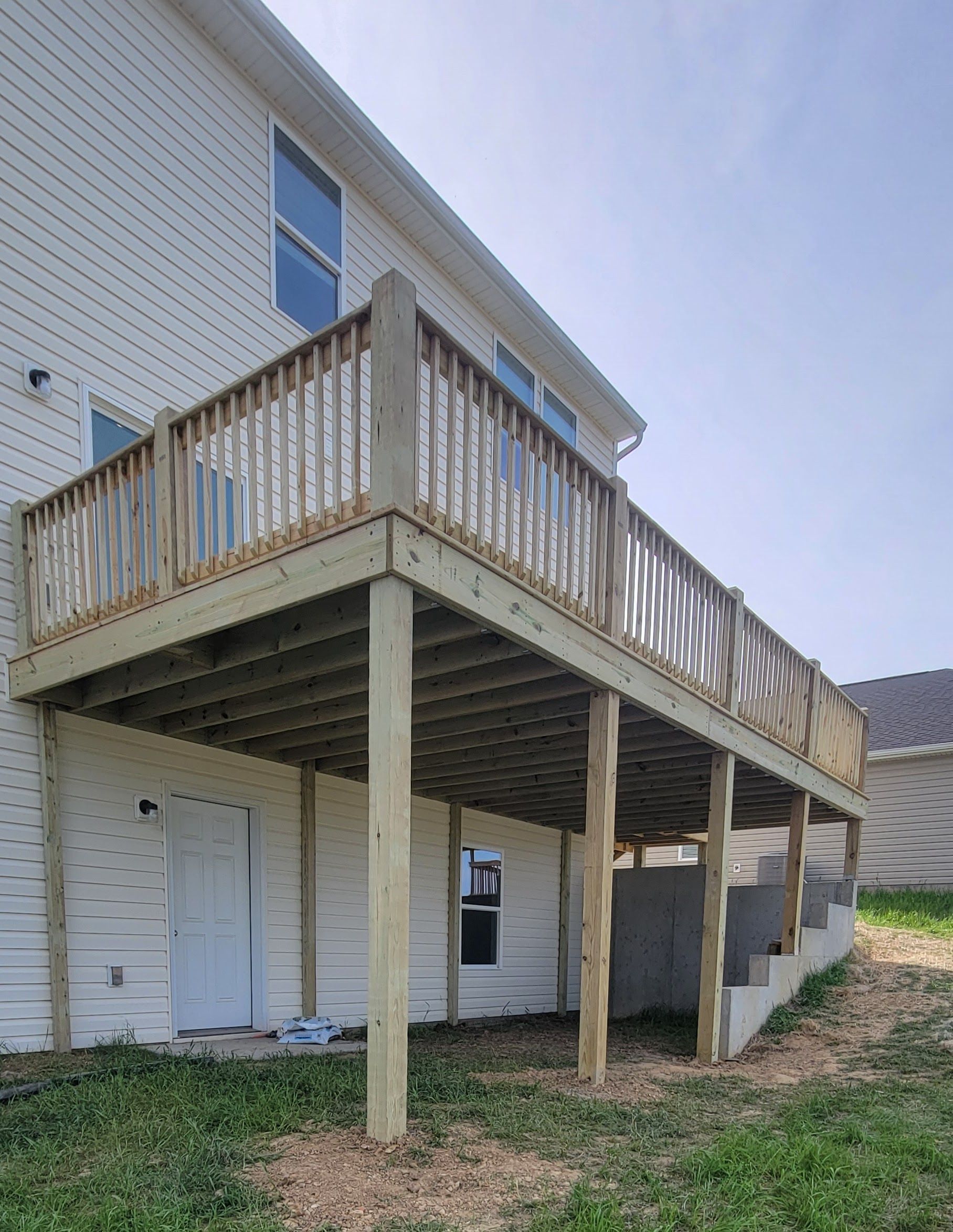 A large wooden deck is in the backyard of a house.