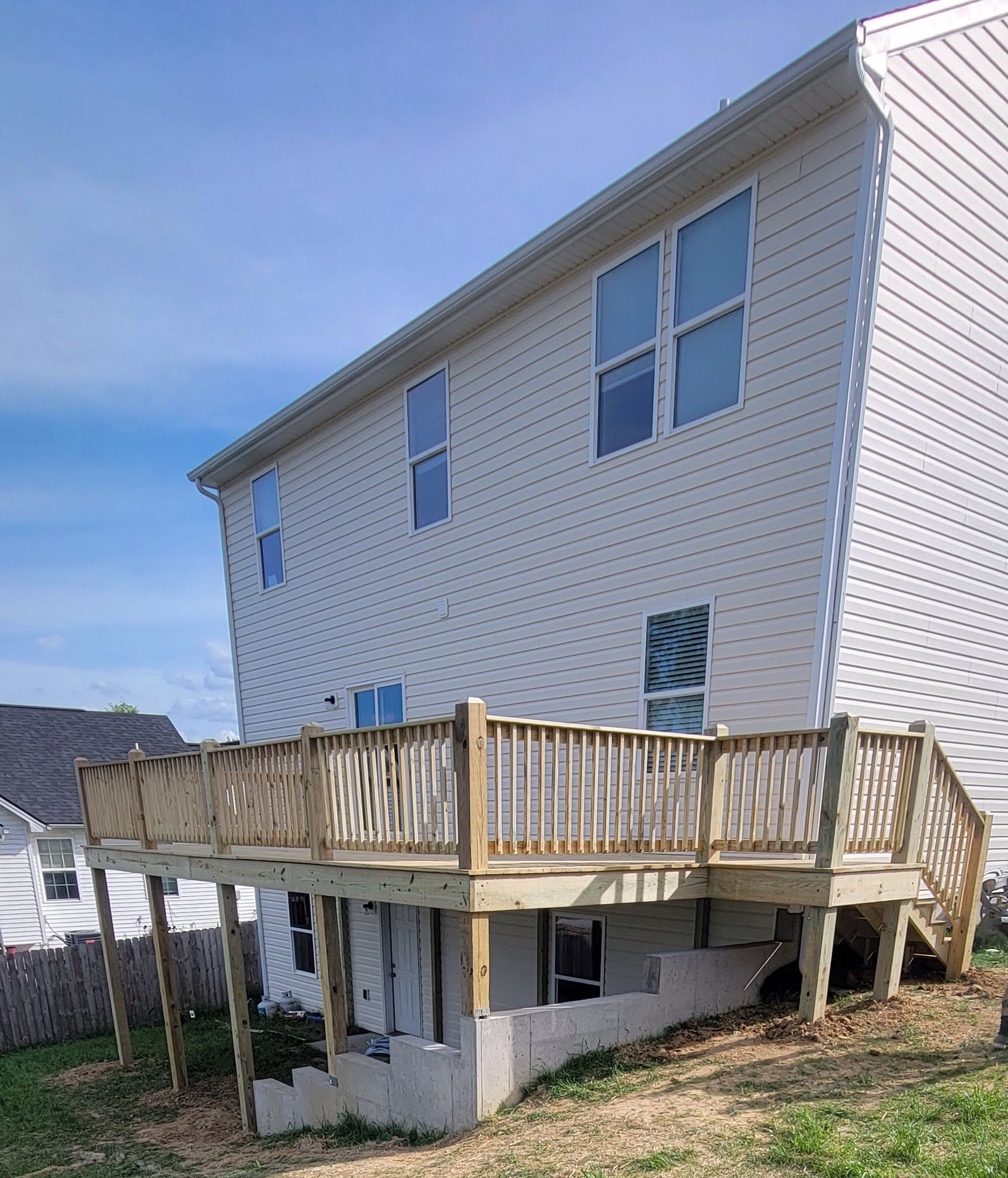 A white house with a wooden deck in front of it