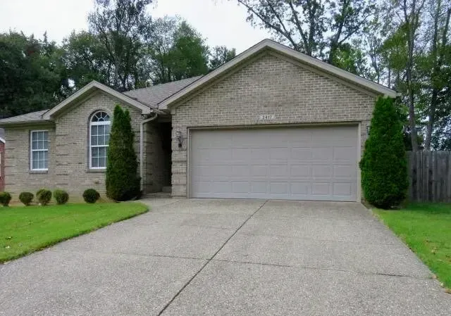 A brick house with a white garage door and a driveway