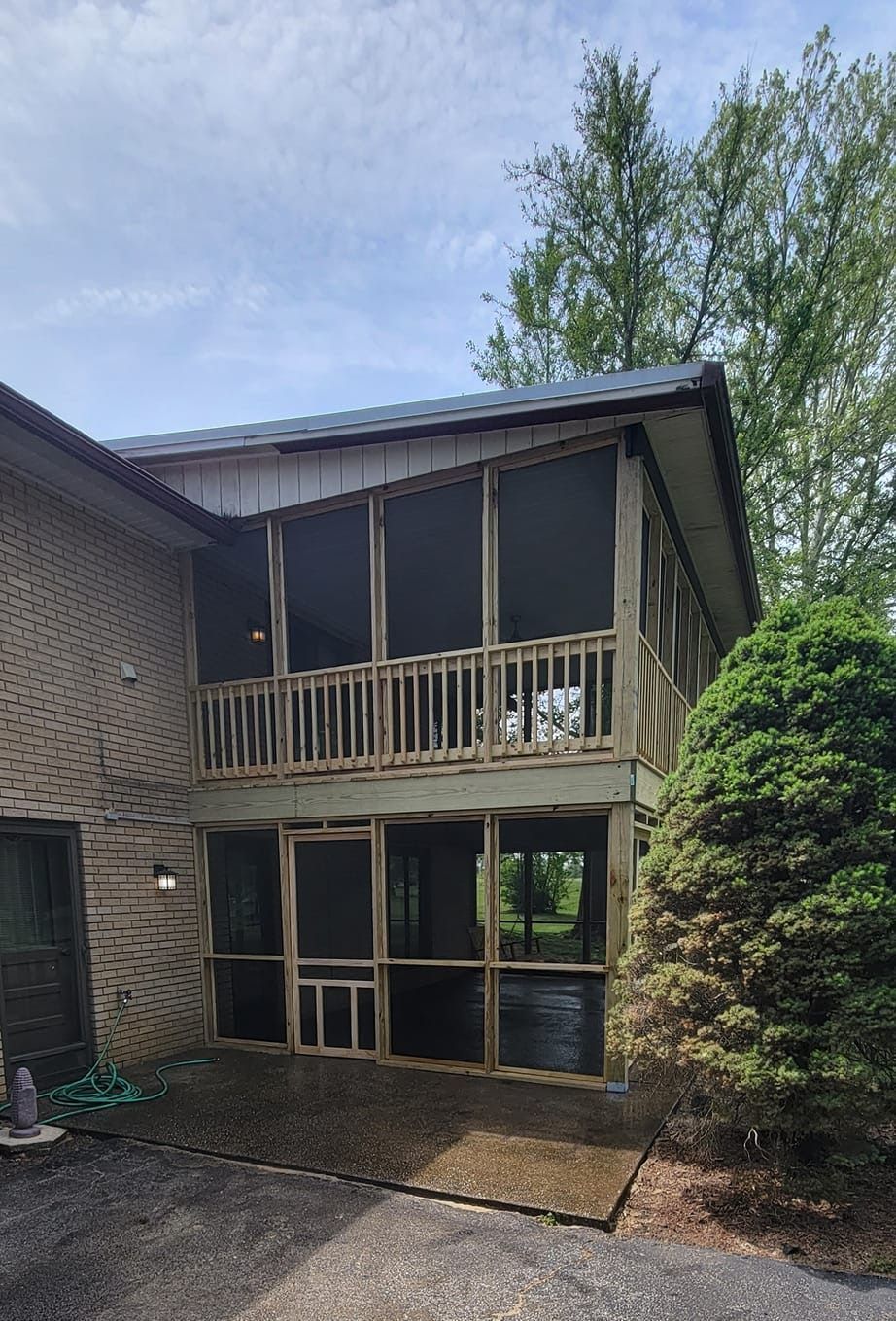 A house with a screened in porch and a balcony.