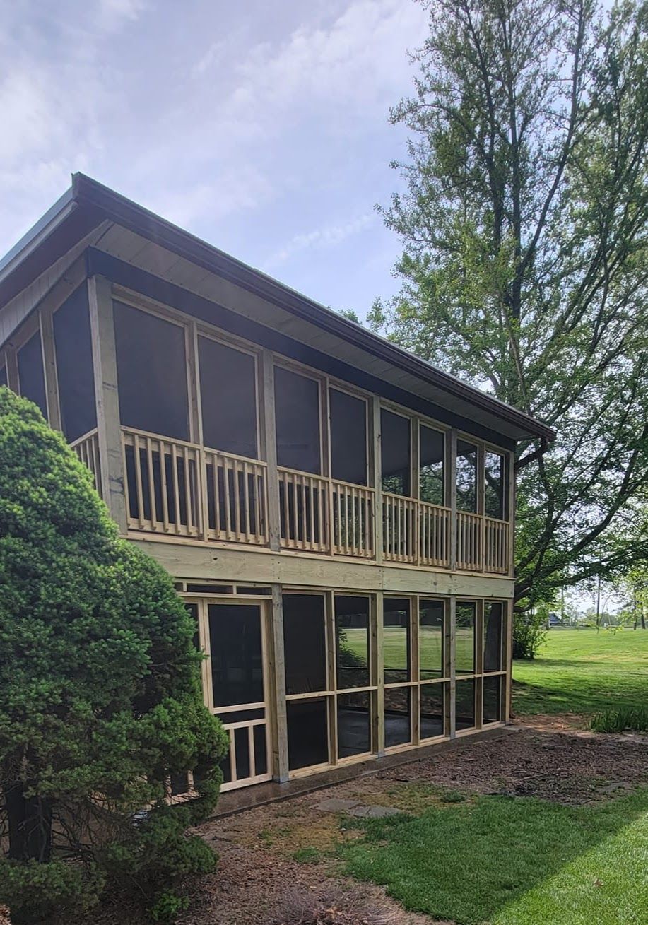 A screened in porch is being built in the backyard of a house.