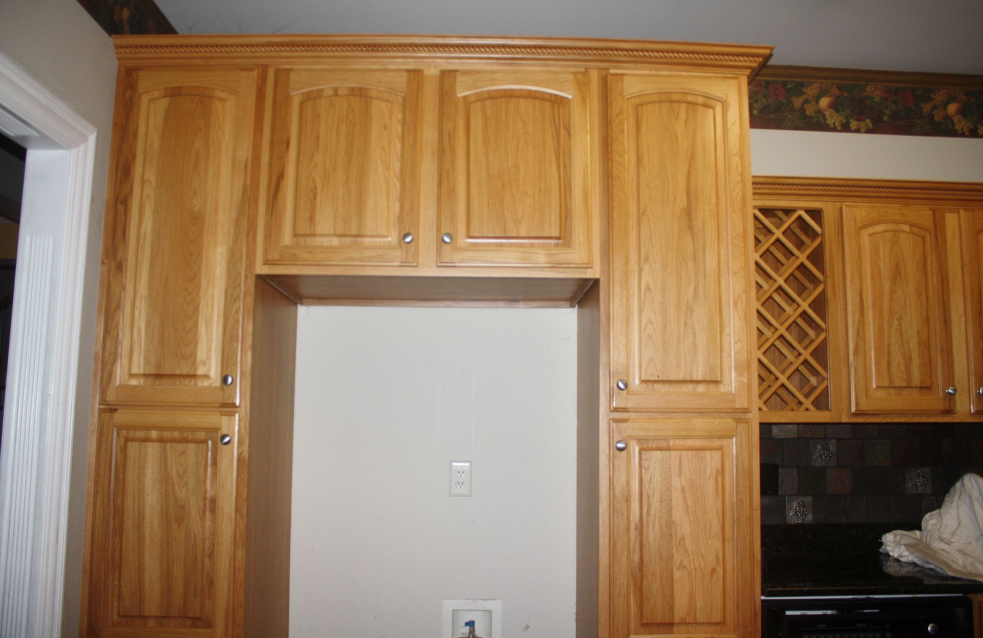 A kitchen with wooden cabinets and a wine rack