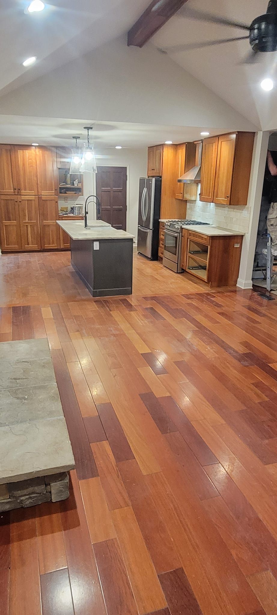 A kitchen with hardwood floors and a ceiling fan.