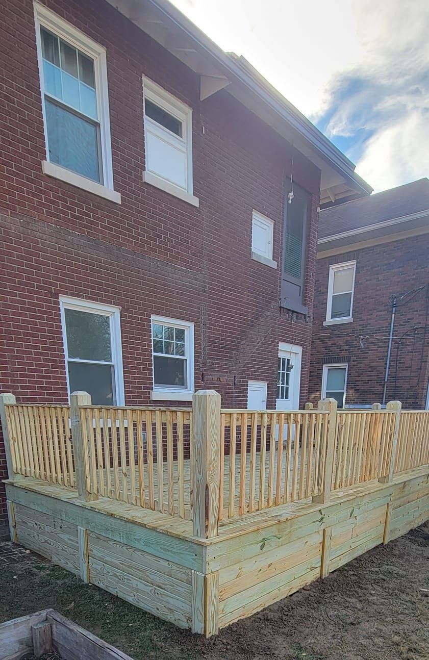 A wooden deck is being built in front of a brick building.