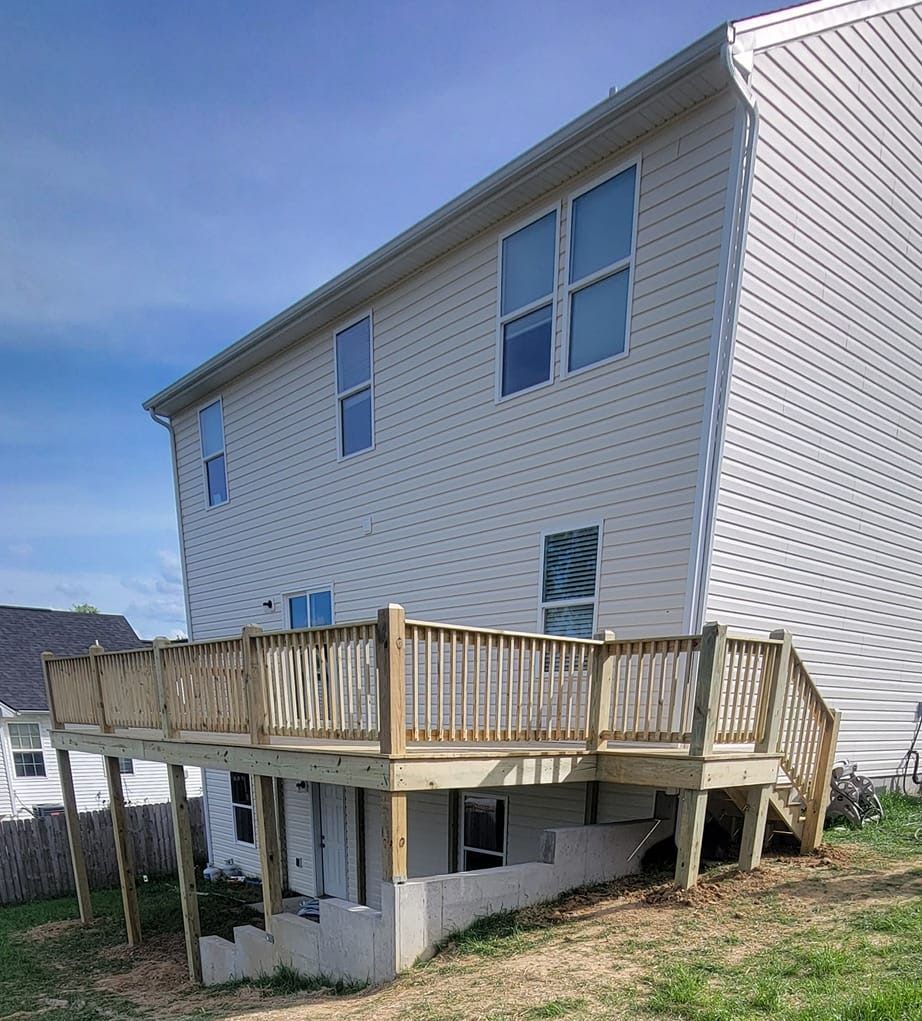 A white house with a wooden deck in front of it