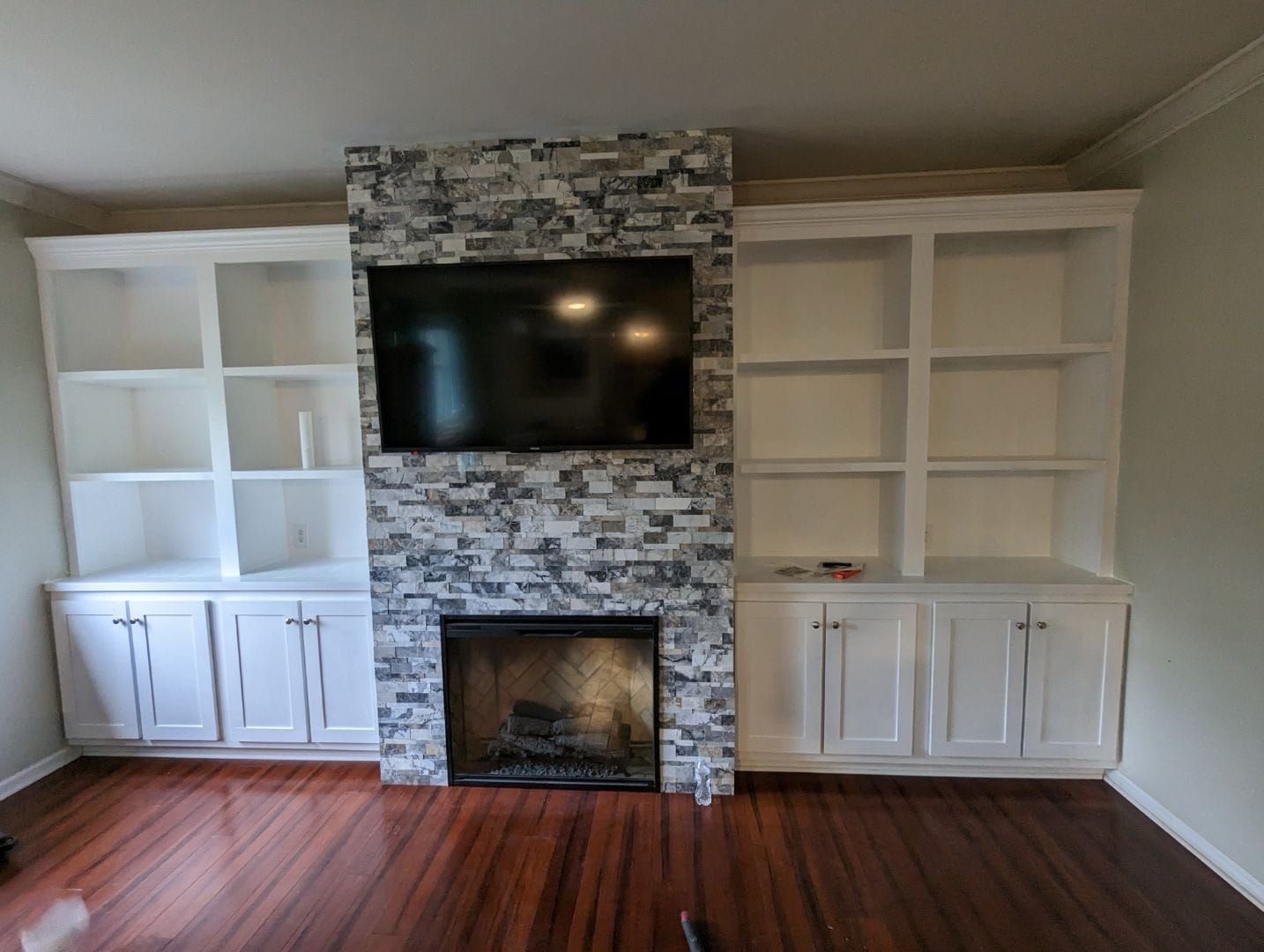 A living room with a fireplace and a flat screen tv