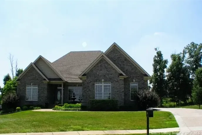 A large brick house with a mailbox in front of it
