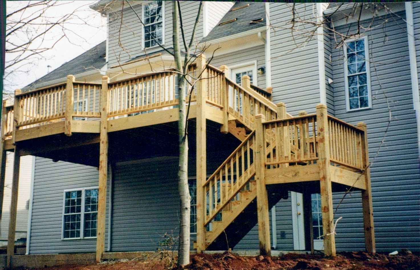 The back of a house with a wooden deck and stairs