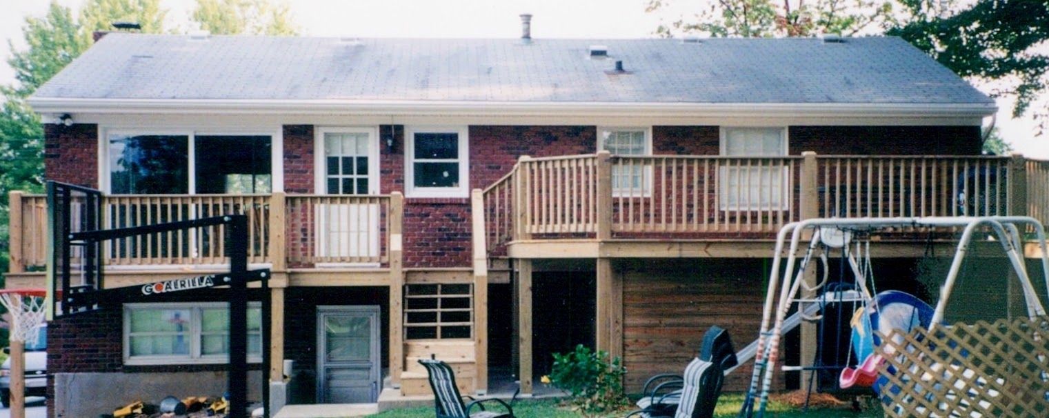 A brick house with a wooden deck and a basketball hoop