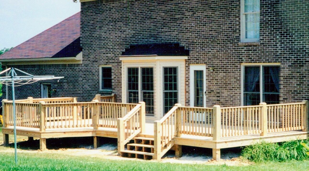 A brick house with a wooden deck in front of it