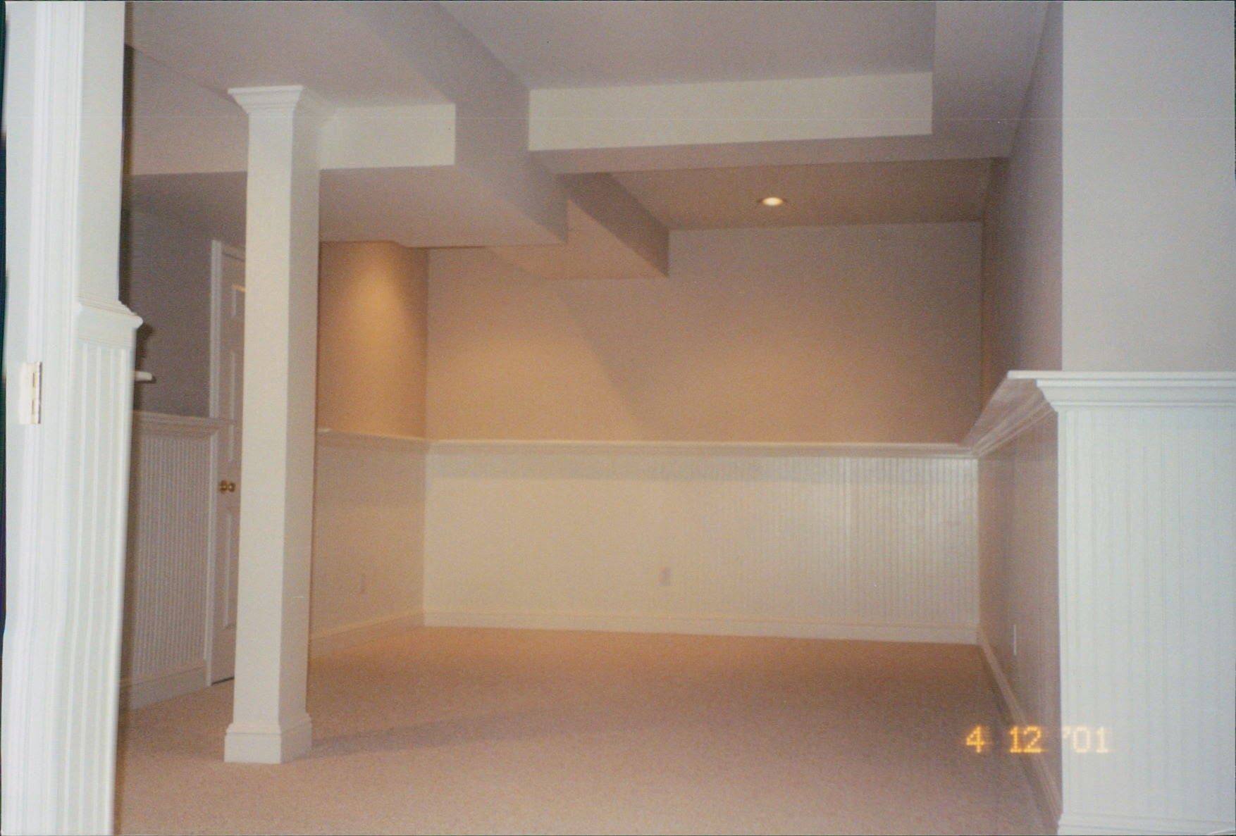 An empty basement with white walls and columns