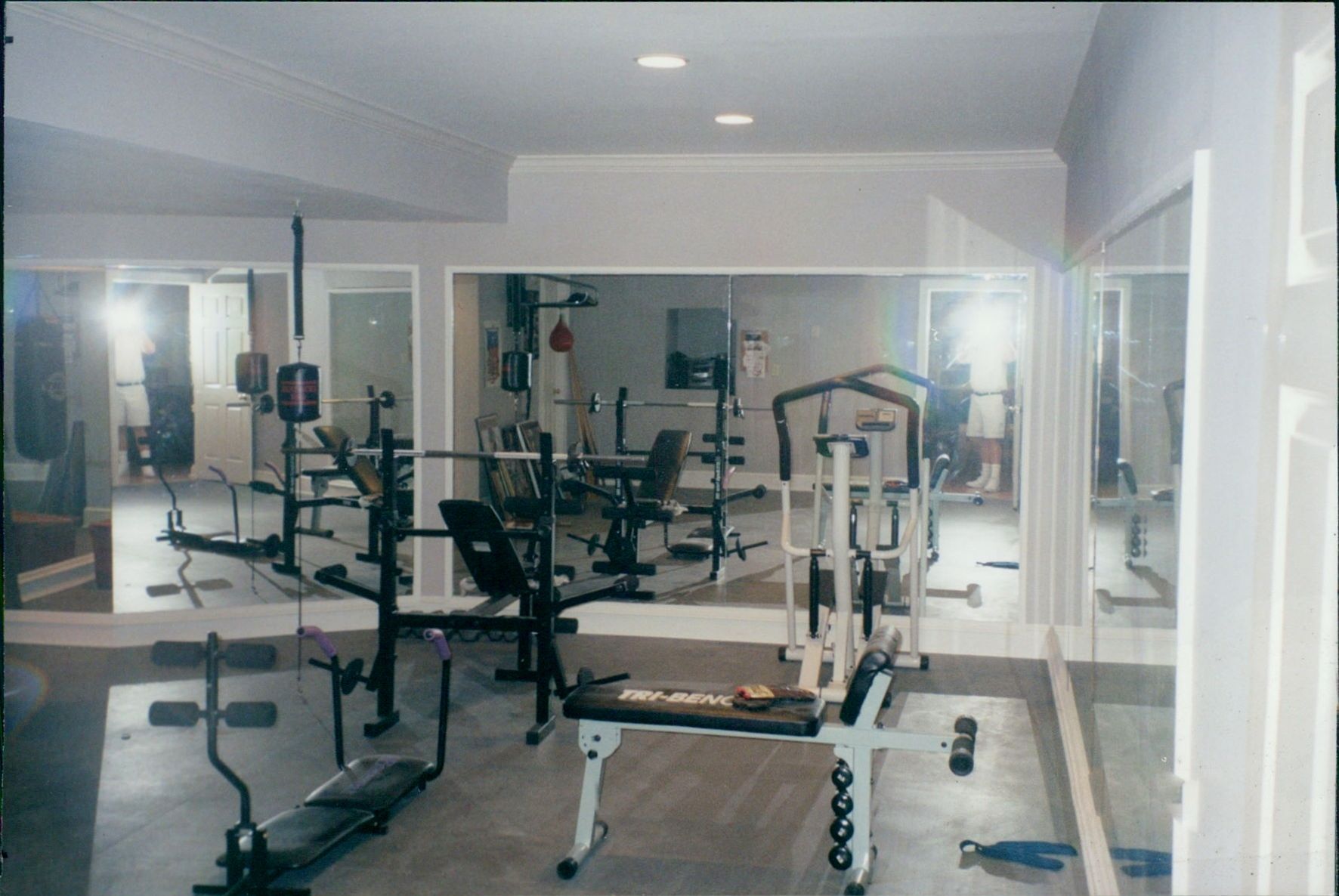 A gym with a lot of exercise equipment and mirrors