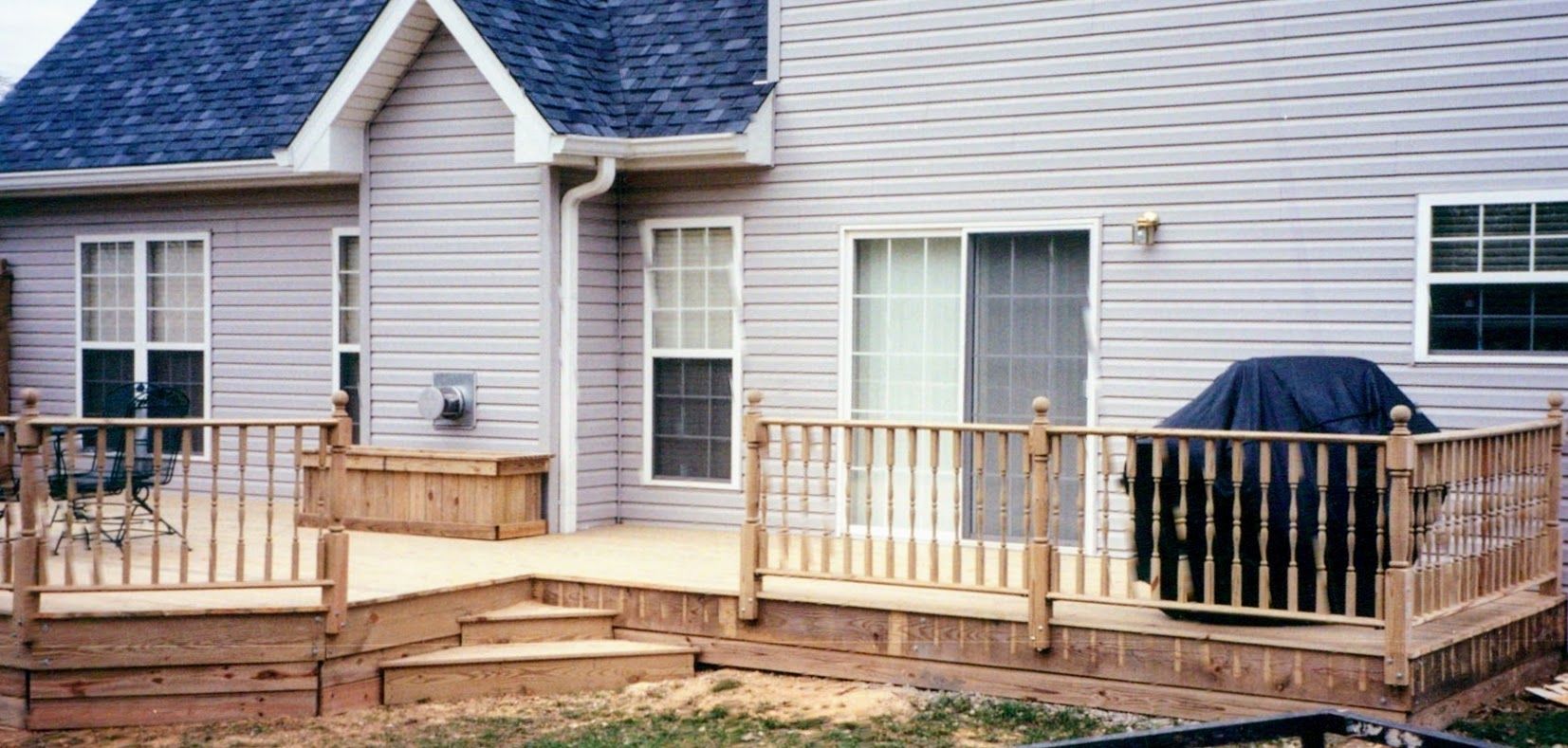 A white house with a wooden deck in front of it