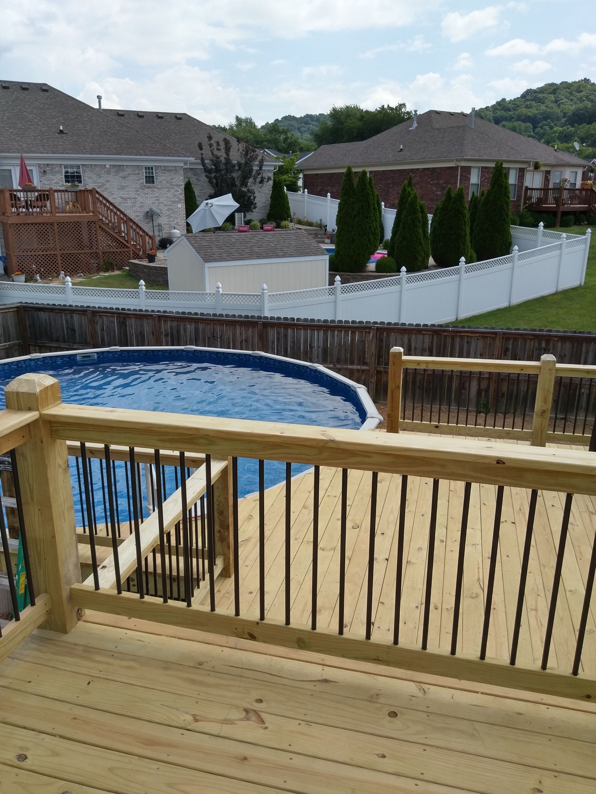 A view of a swimming pool from a wooden deck
