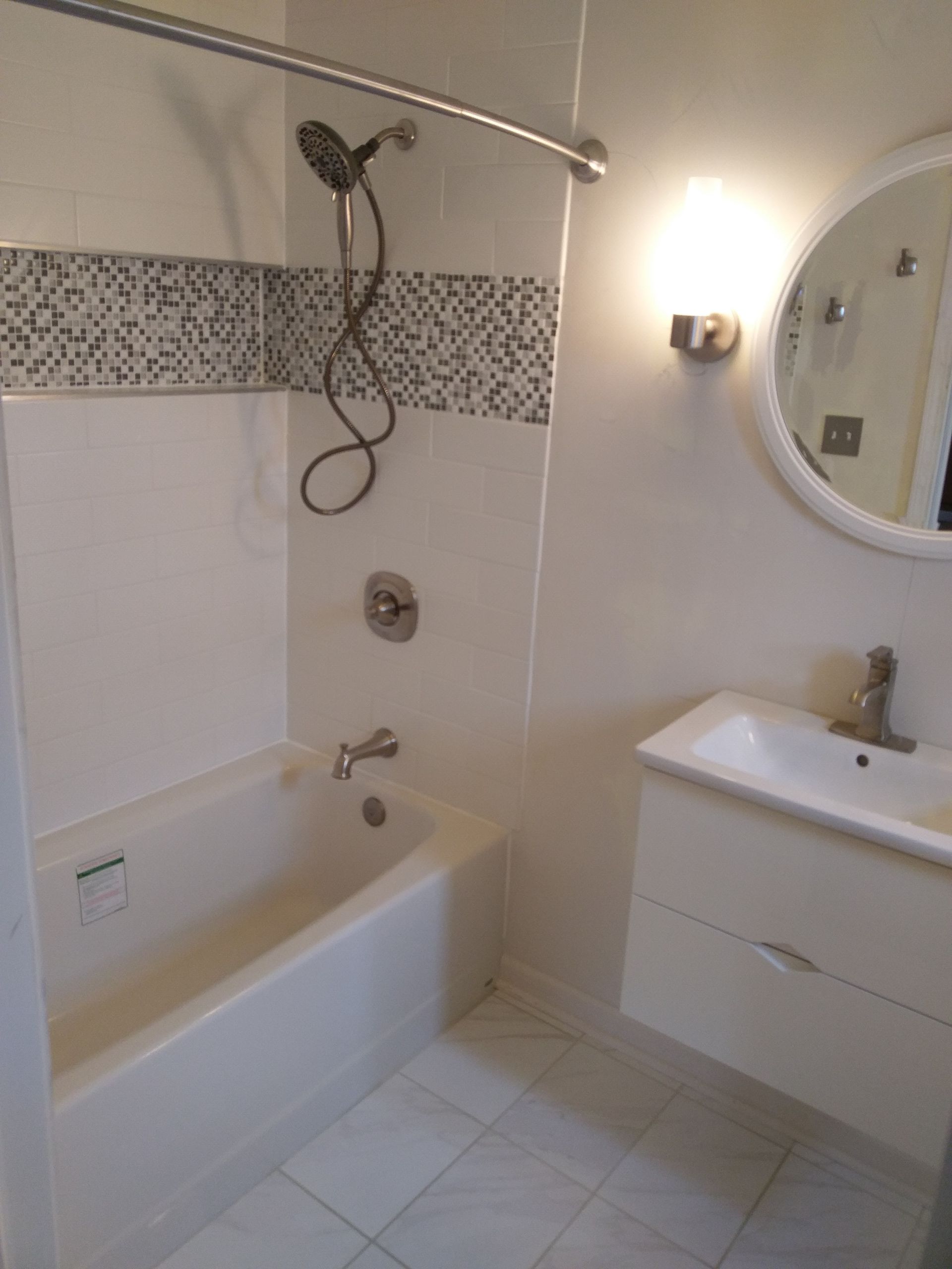 A bathroom with a bathtub a sink and a mirror