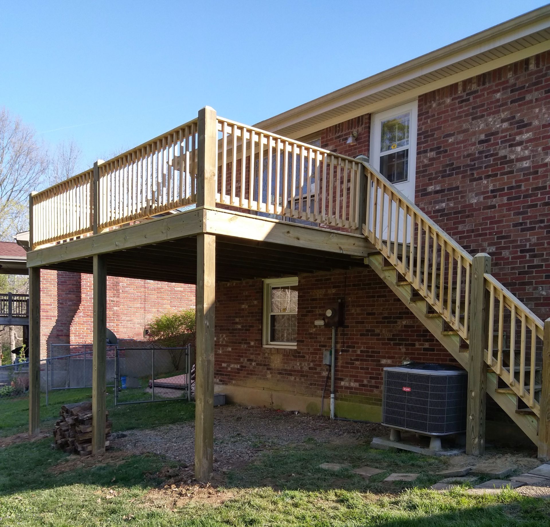 A brick house with a wooden deck and stairs