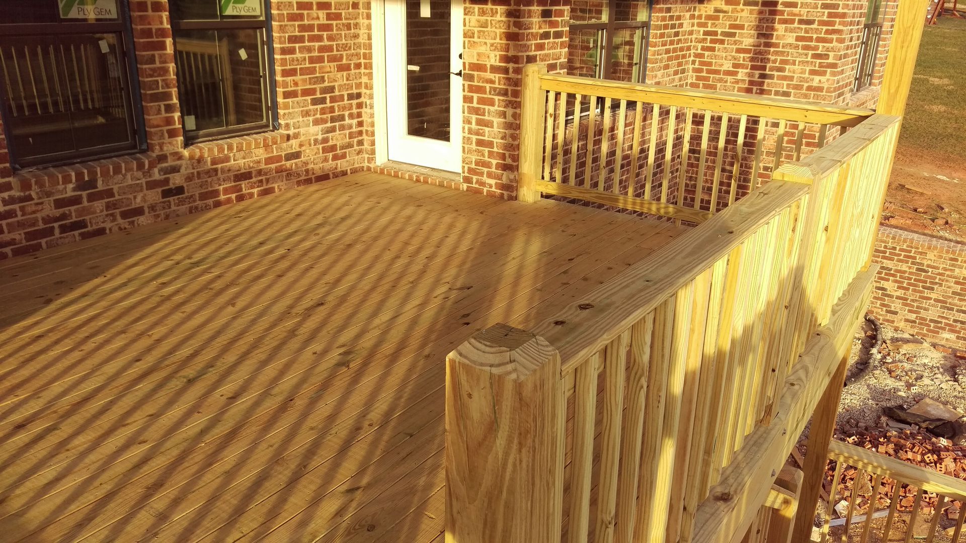 A wooden deck with a brick building in the background.