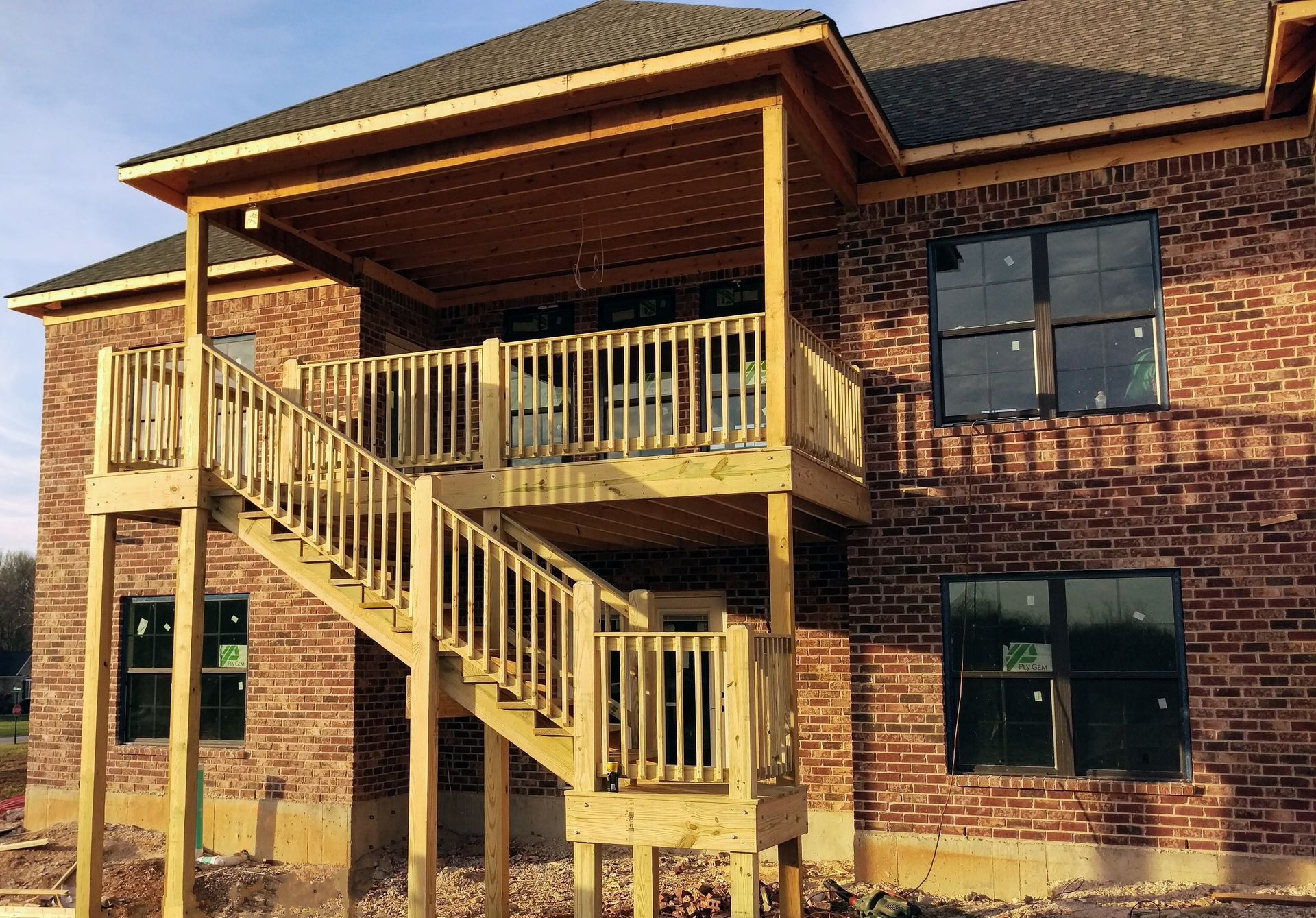 A brick house with a wooden deck and stairs