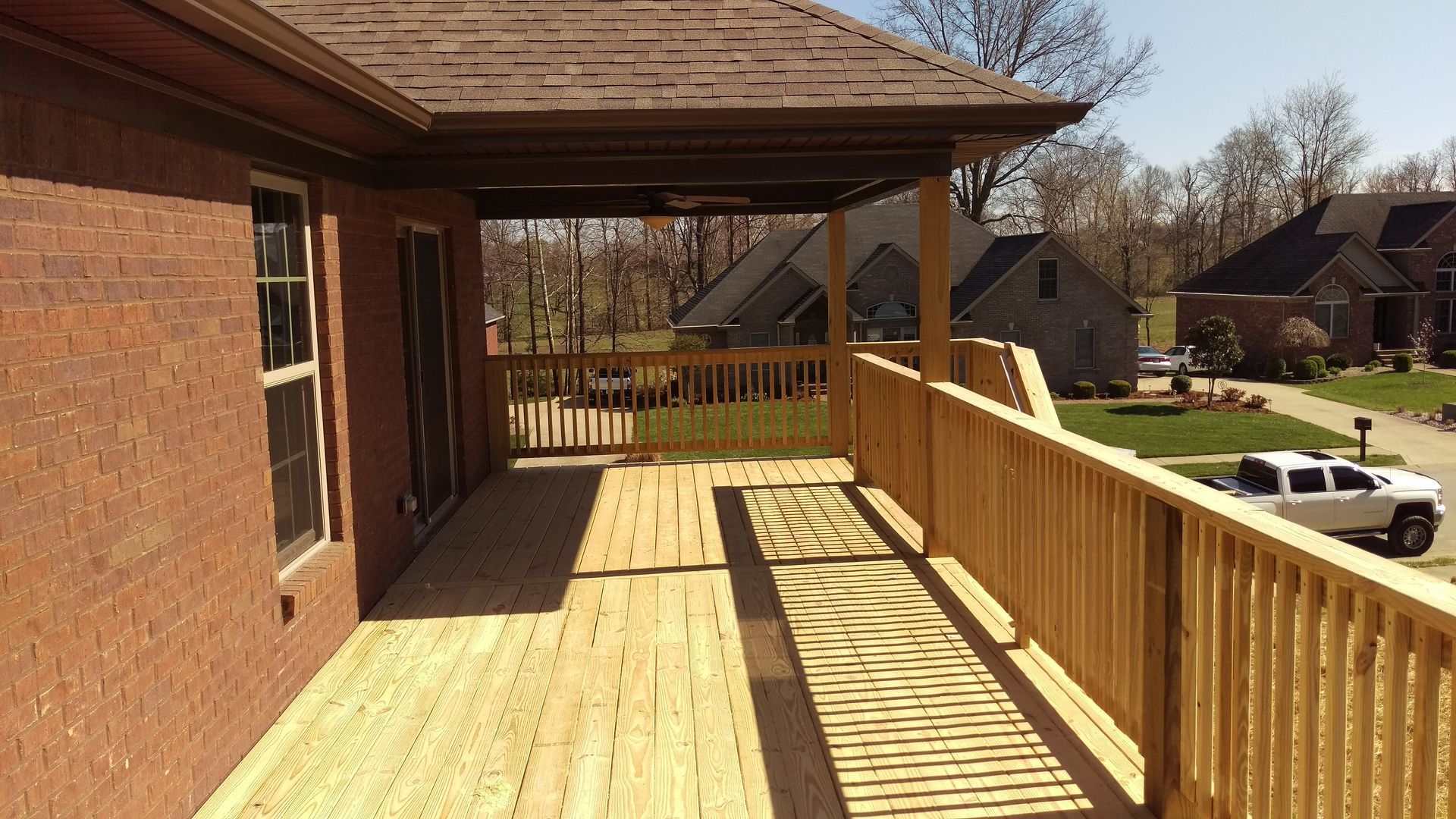 A brick house with a wooden deck in front of it