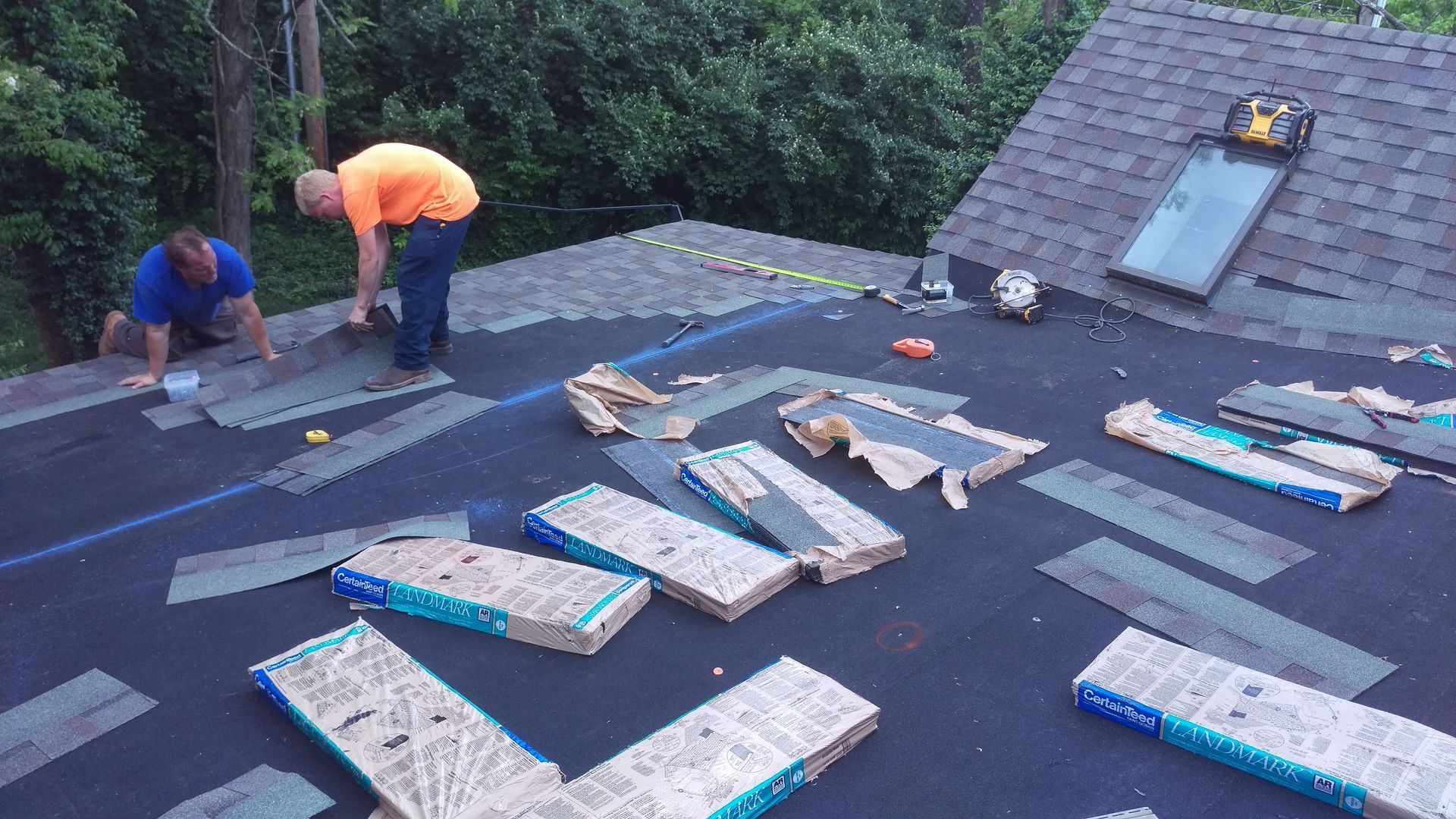Two men are working on the roof of a house.