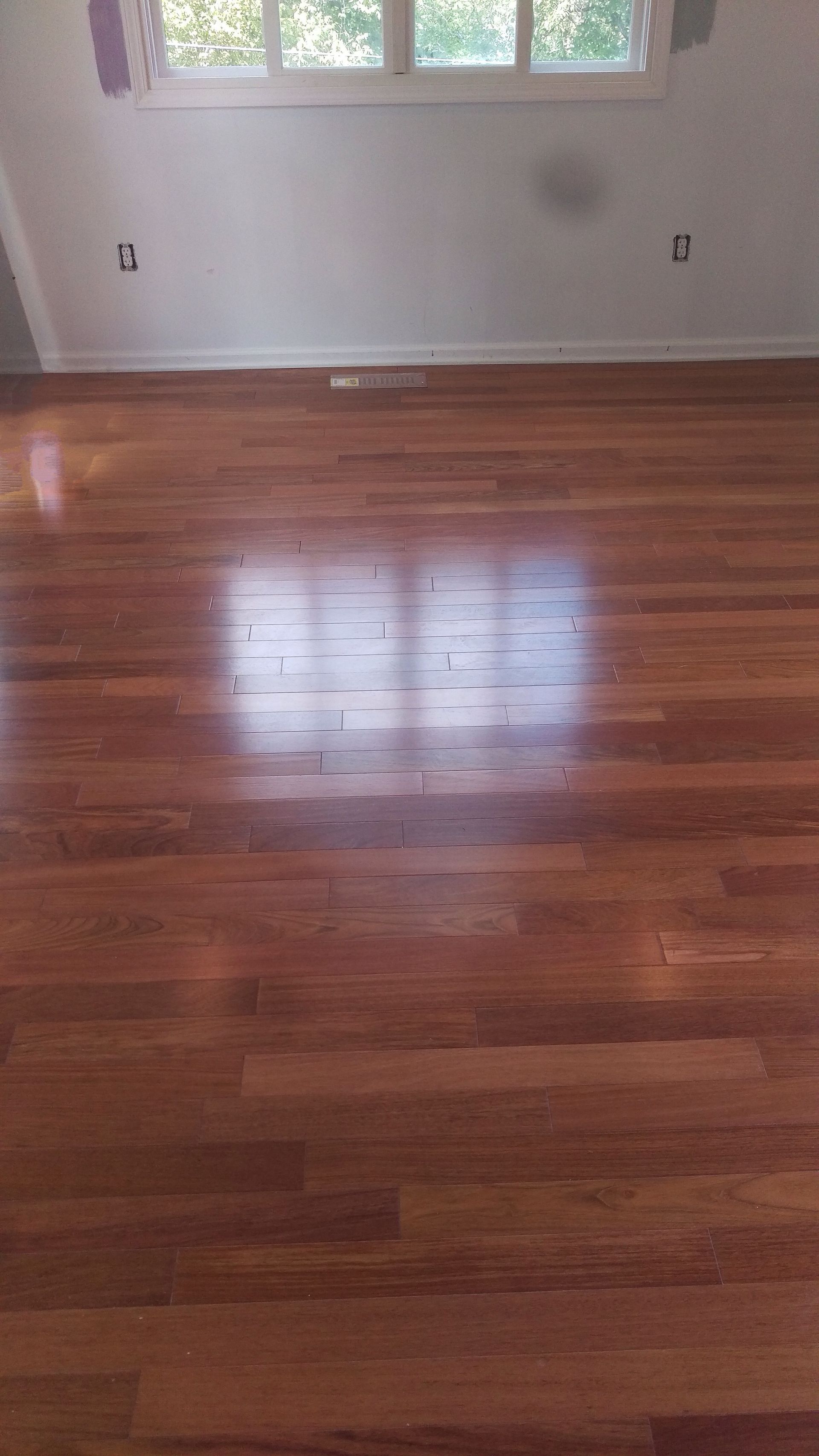 A room with a wooden floor and a window.