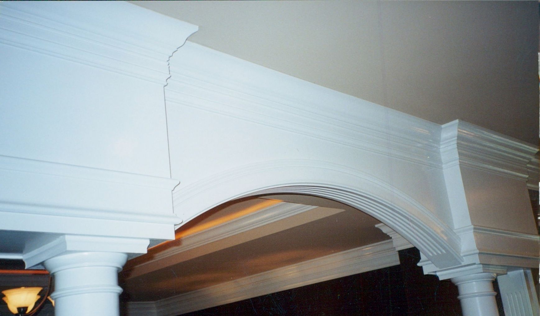 A white archway with columns in a room