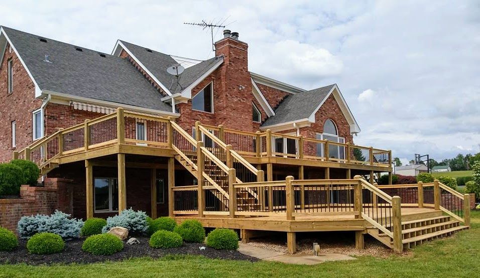 A large brick house with a wooden deck in front of it.