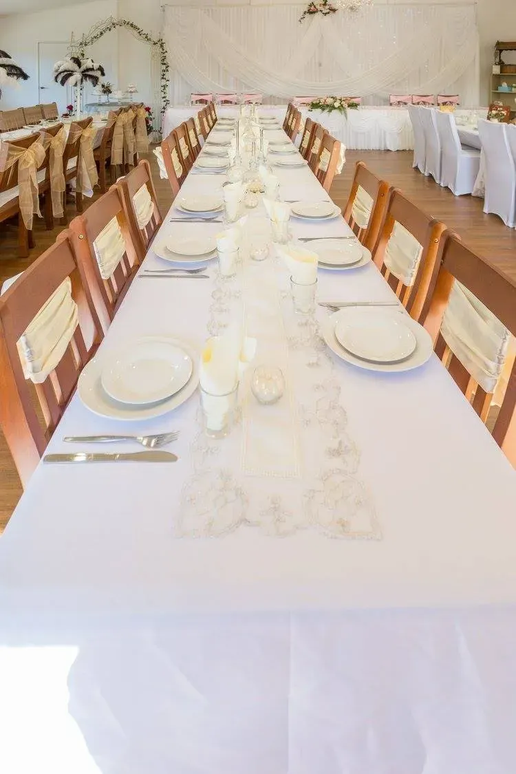 Long Wedding Reception Table Set With White Linens and Place Settings — Villa Lamor in Balberra, QLD