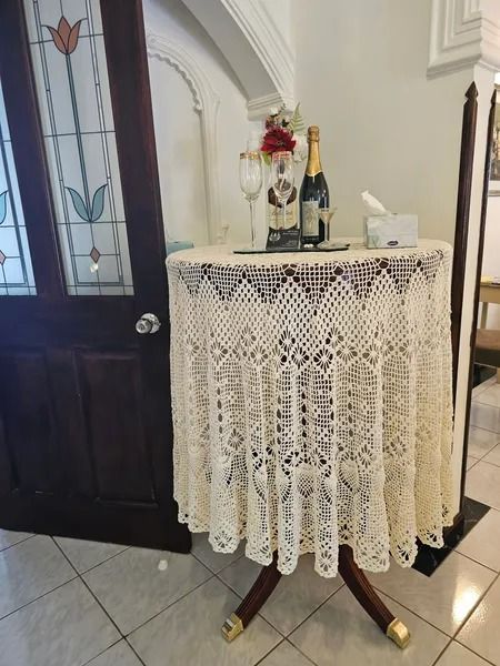 Small Round Table Covered With a Cream-colored Lace Tablecloth — Villa Lamor in Balberra, QLD